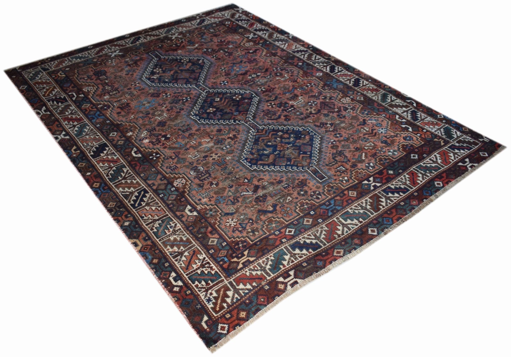 A vintage handwoven Persian Shiraz rug featuring a geometric medallion pattern in earthy tones.