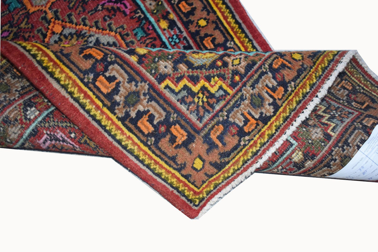 A vintage Persian Shiraz rug with a geometric pattern in red, blue, and orange wool.