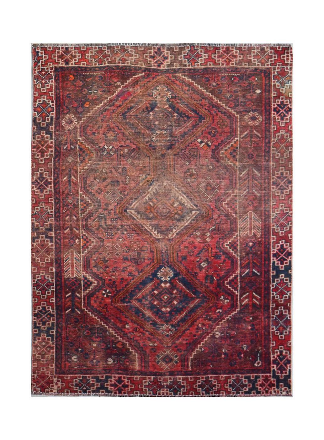 A handwoven vintage Persian Shiraz rug featuring a geometric diamond pattern in red and blue tones.