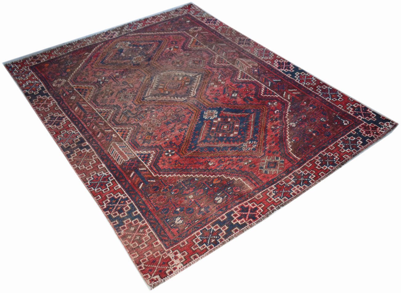 A vintage handwoven Persian Shiraz rug featuring a geometric diamond pattern in red and blue tones.