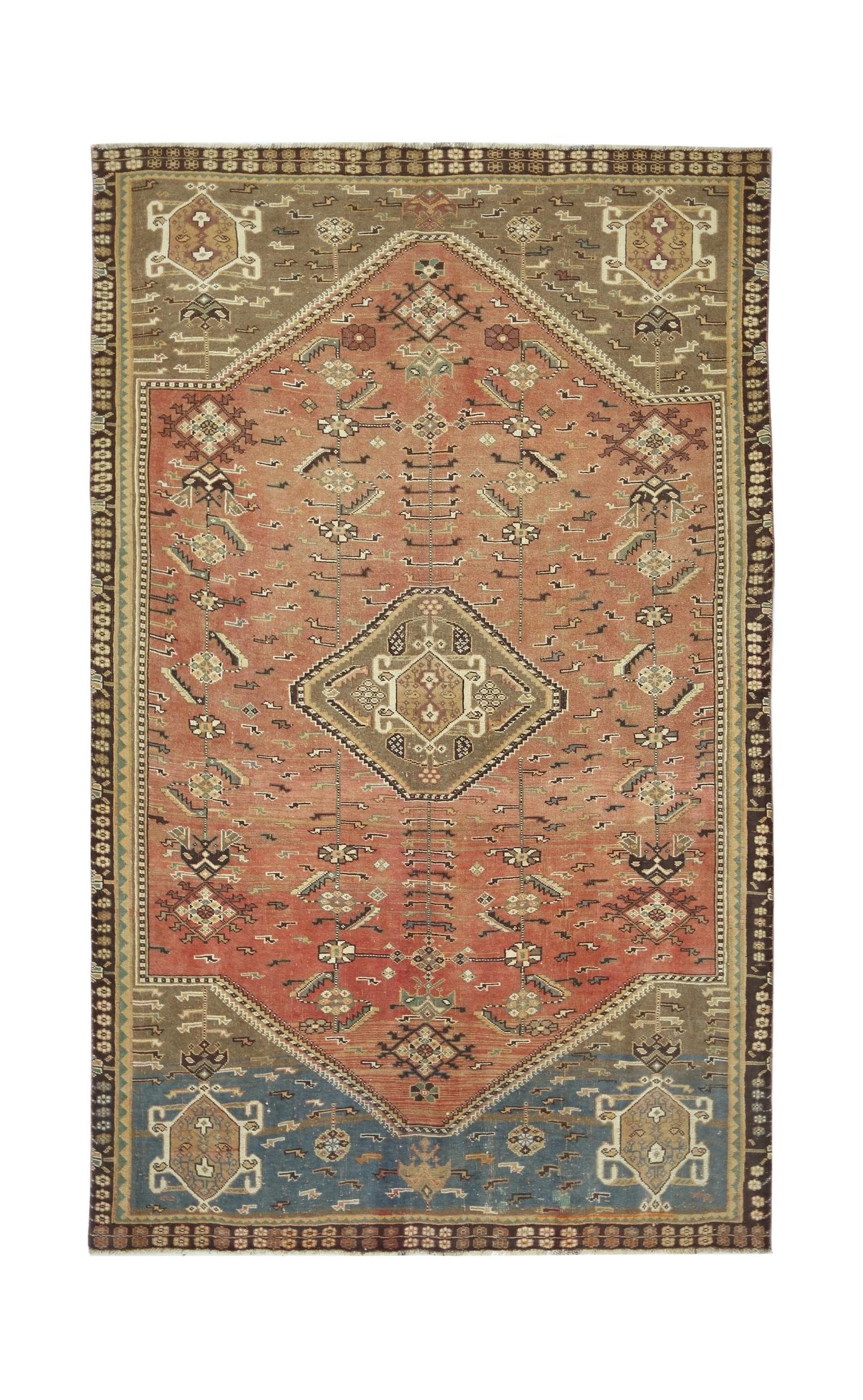 A vintage Persian Shiraz rug featuring a central diamond medallion on a terracotta field.