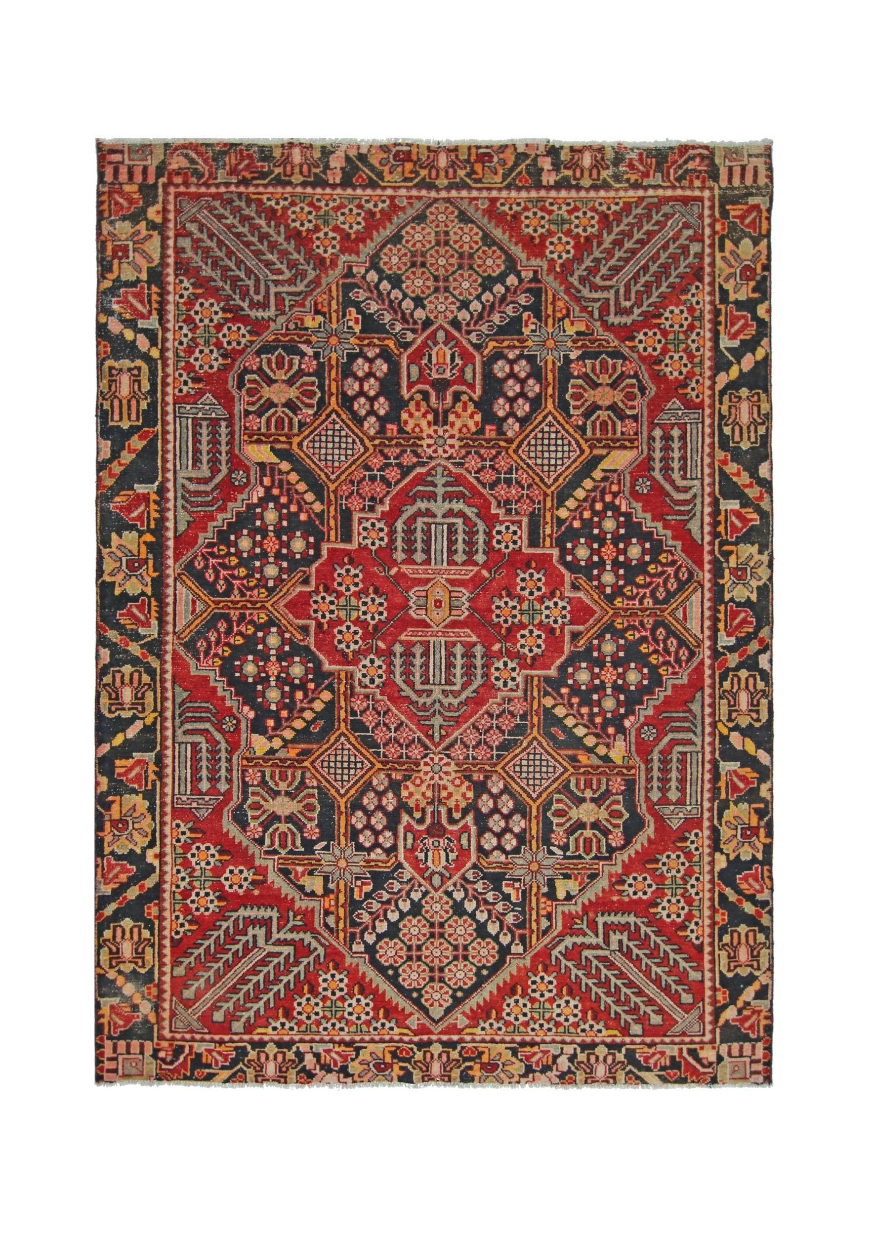 A vintage Persian Tabriz rug featuring a geometric floral pattern in red, navy, and cream tones.