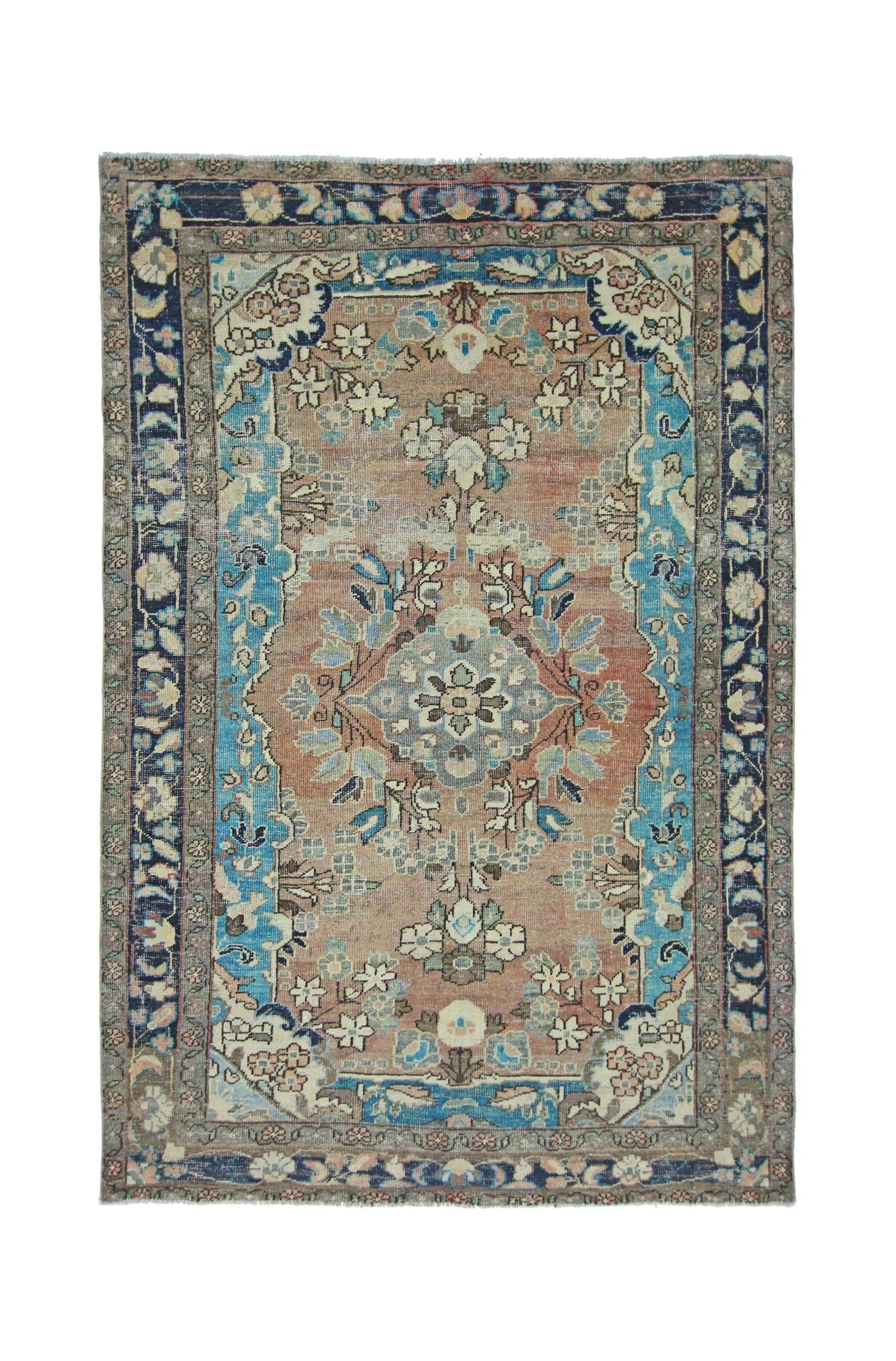 A vintage Persian Tabriz rug featuring a central floral medallion on a muted orange field.
