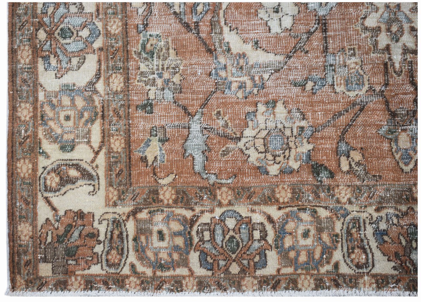 A vintage Persian Tabriz rug featuring a floral pattern in rust, cream, and blue tones.