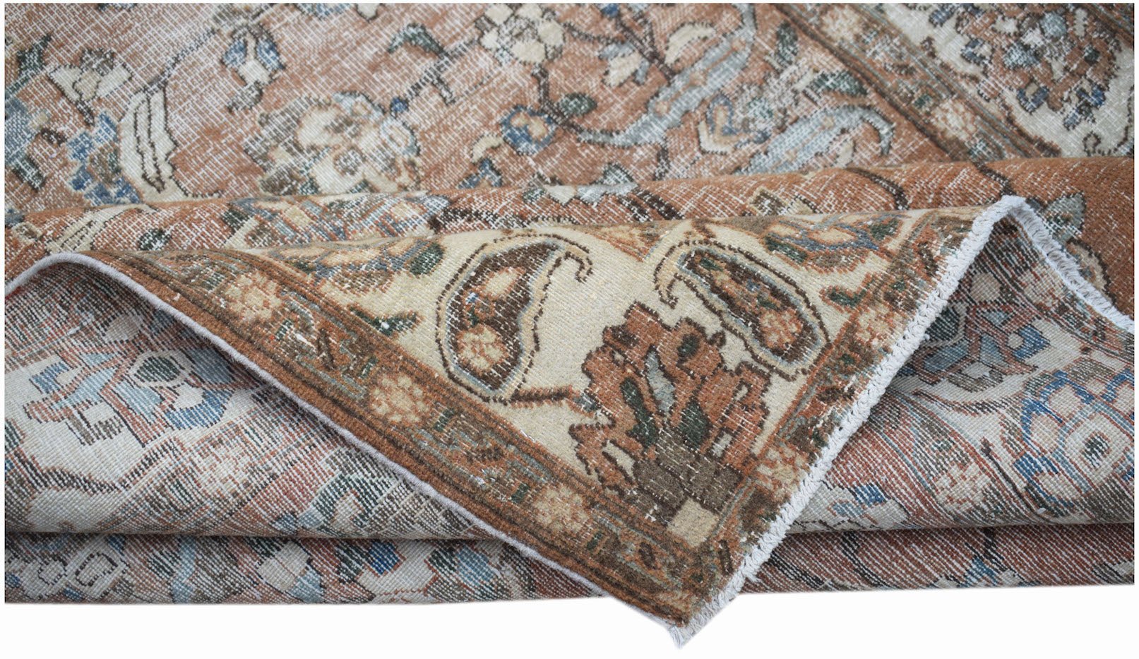 A vintage Persian Tabriz rug featuring a faded floral pattern in shades of rust, blue, and cream.