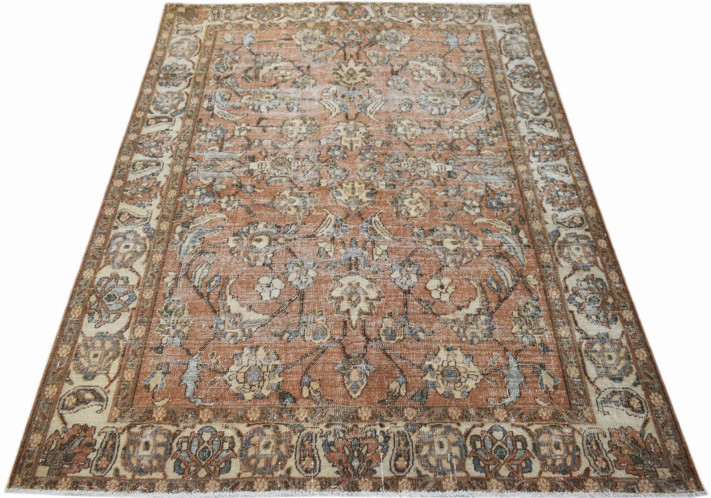 A vintage handwoven Persian Tabriz rug featuring a floral pattern in muted orange and blue tones.