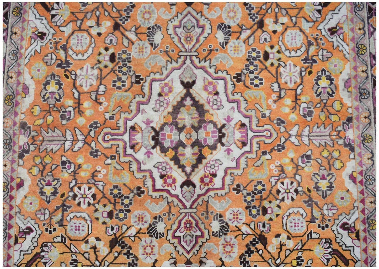 A vintage Persian Tabriz rug featuring a central medallion on an orange field with floral motifs.