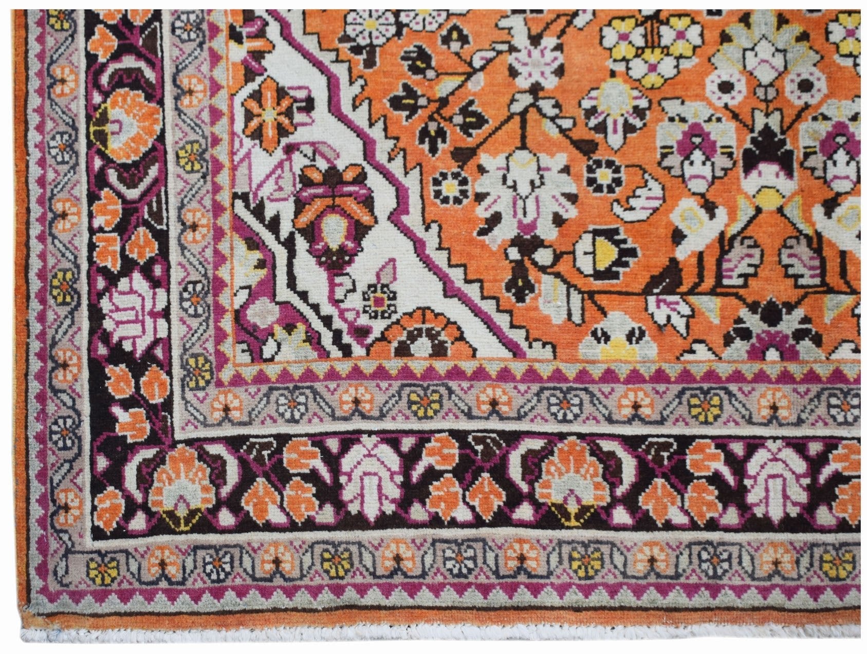 A vintage Persian Tabriz rug featuring an intricate floral pattern in orange, cream, and dark brown.