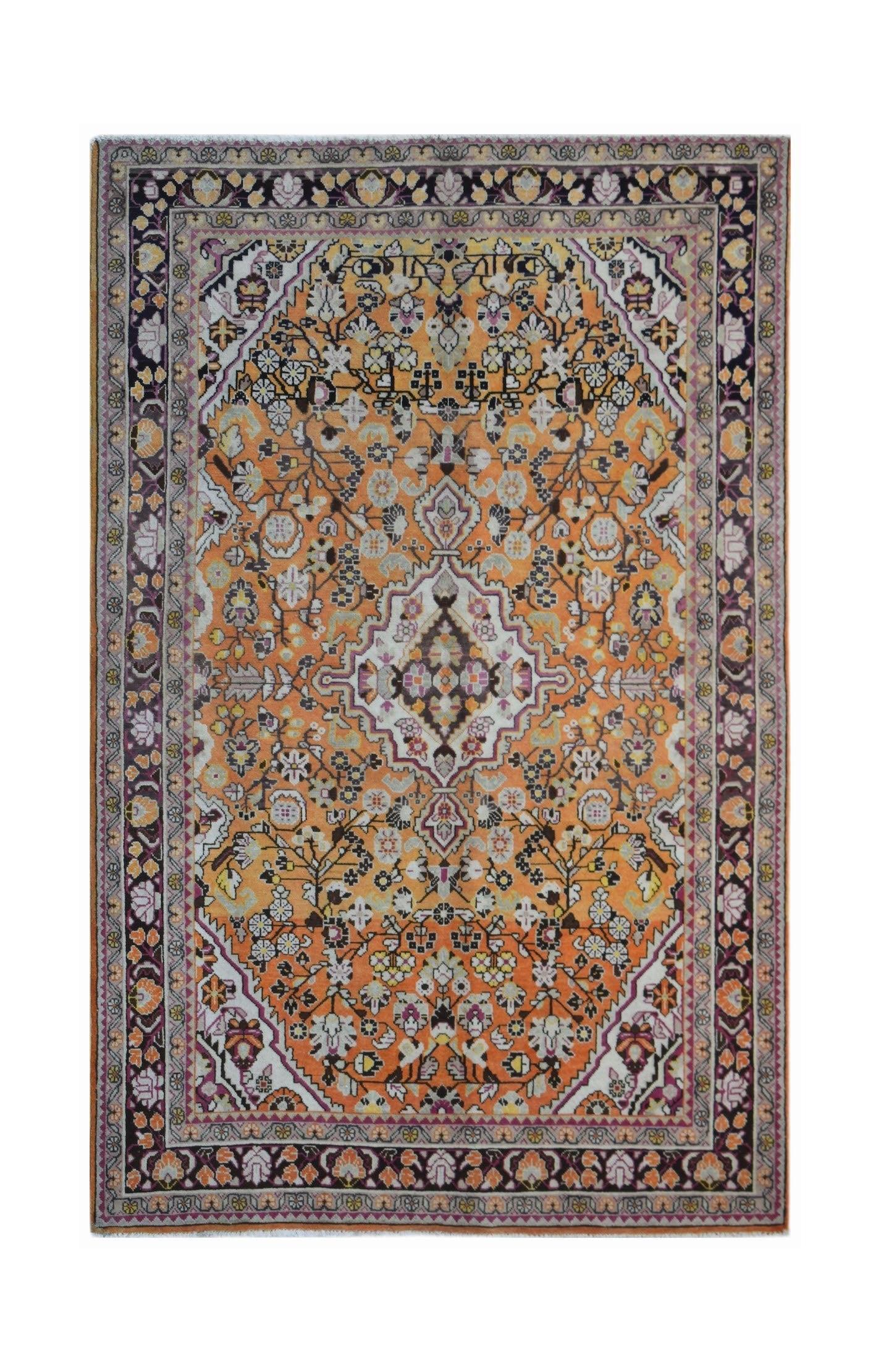 A vintage Persian Tabriz rug featuring an intricate floral pattern in orange, cream, and dark tones.