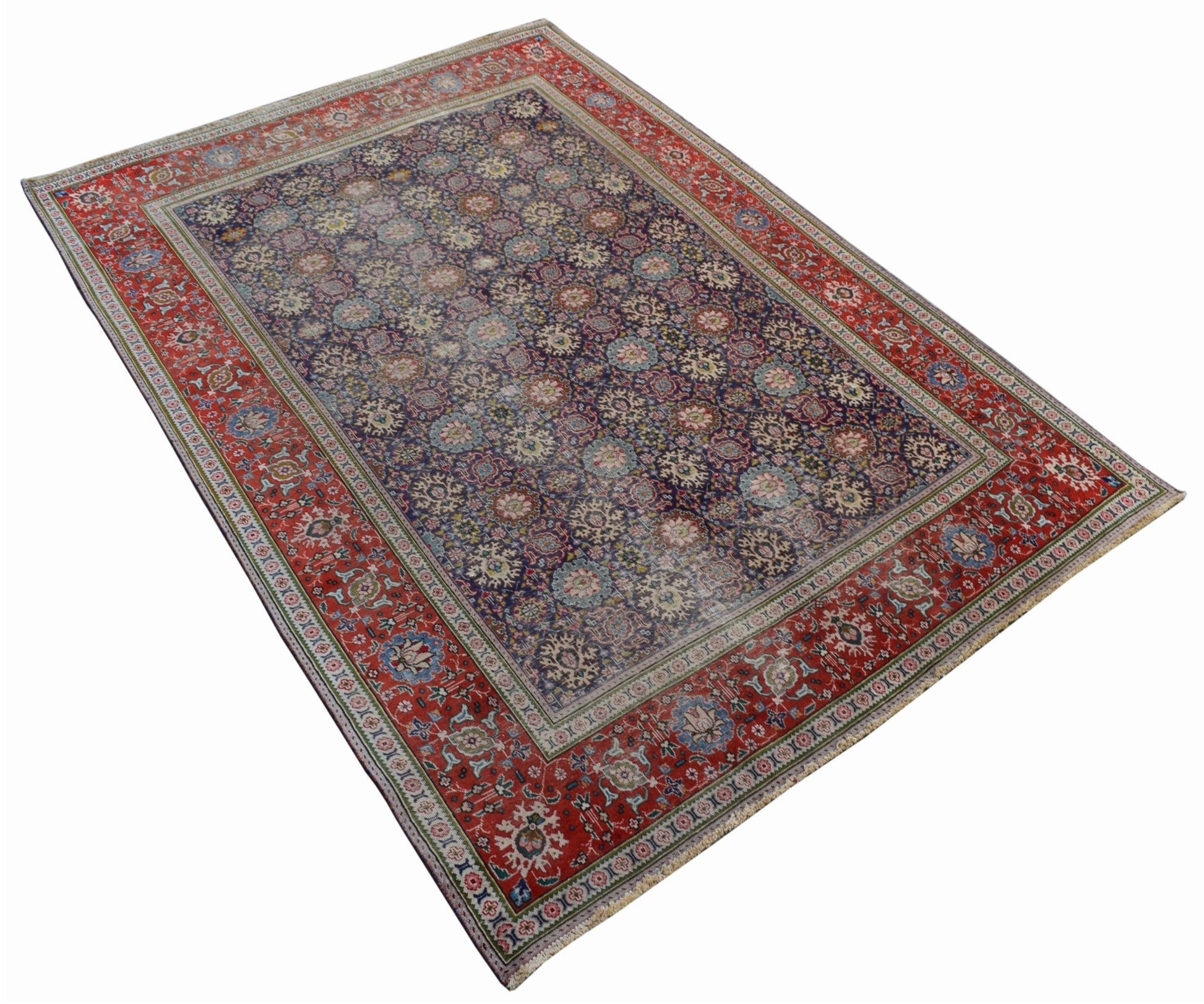 A vintage handwoven Persian Tabriz rug featuring a dark blue field with intricate floral patterns.