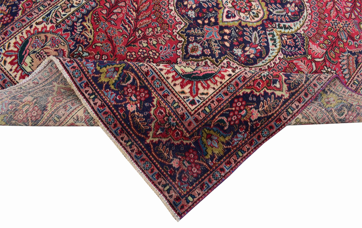 A vintage Persian Tabriz rug featuring a detailed floral medallion pattern in red and navy blue.