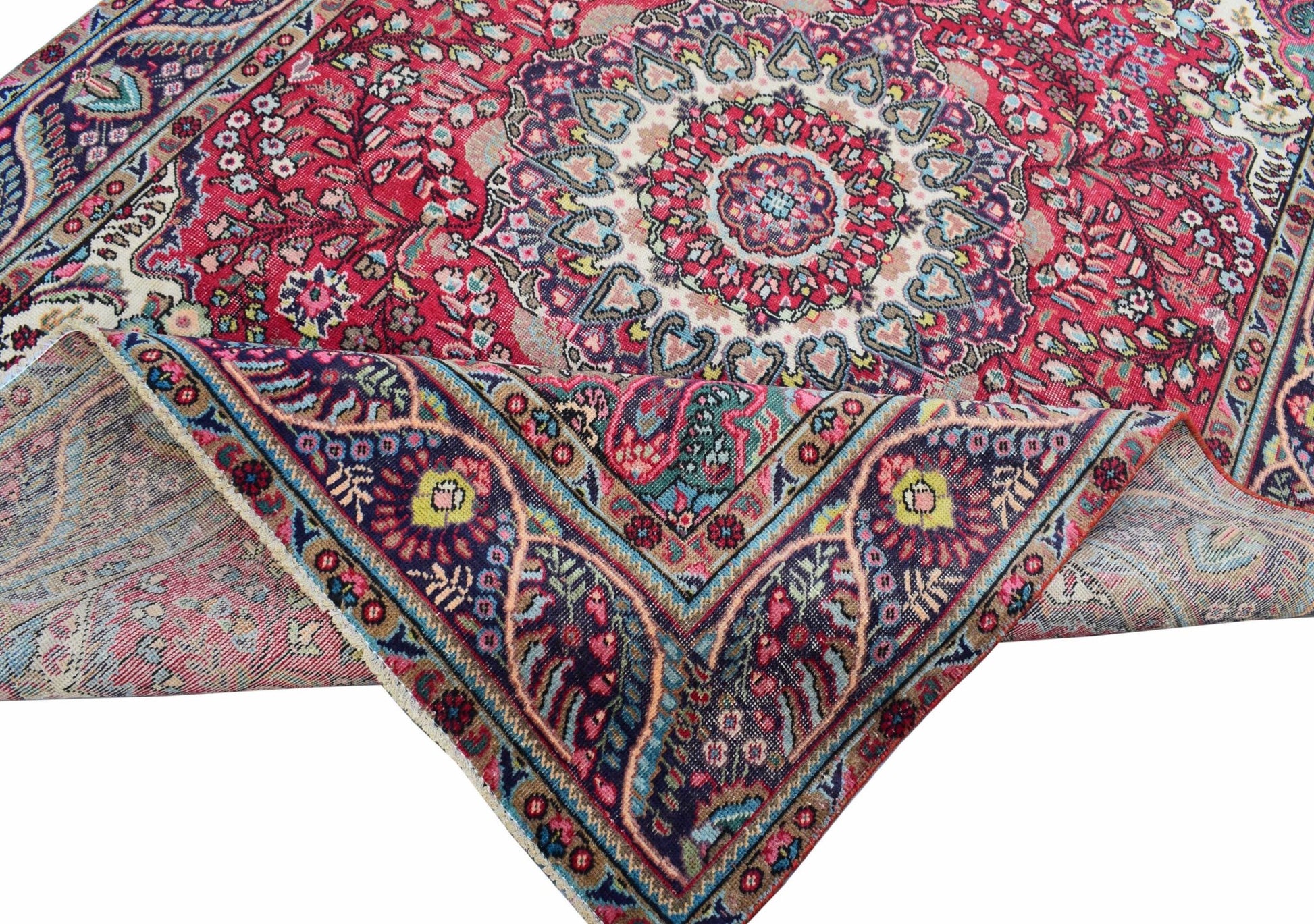 A vintage Persian Tabriz rug featuring a central medallion and intricate floral patterns.