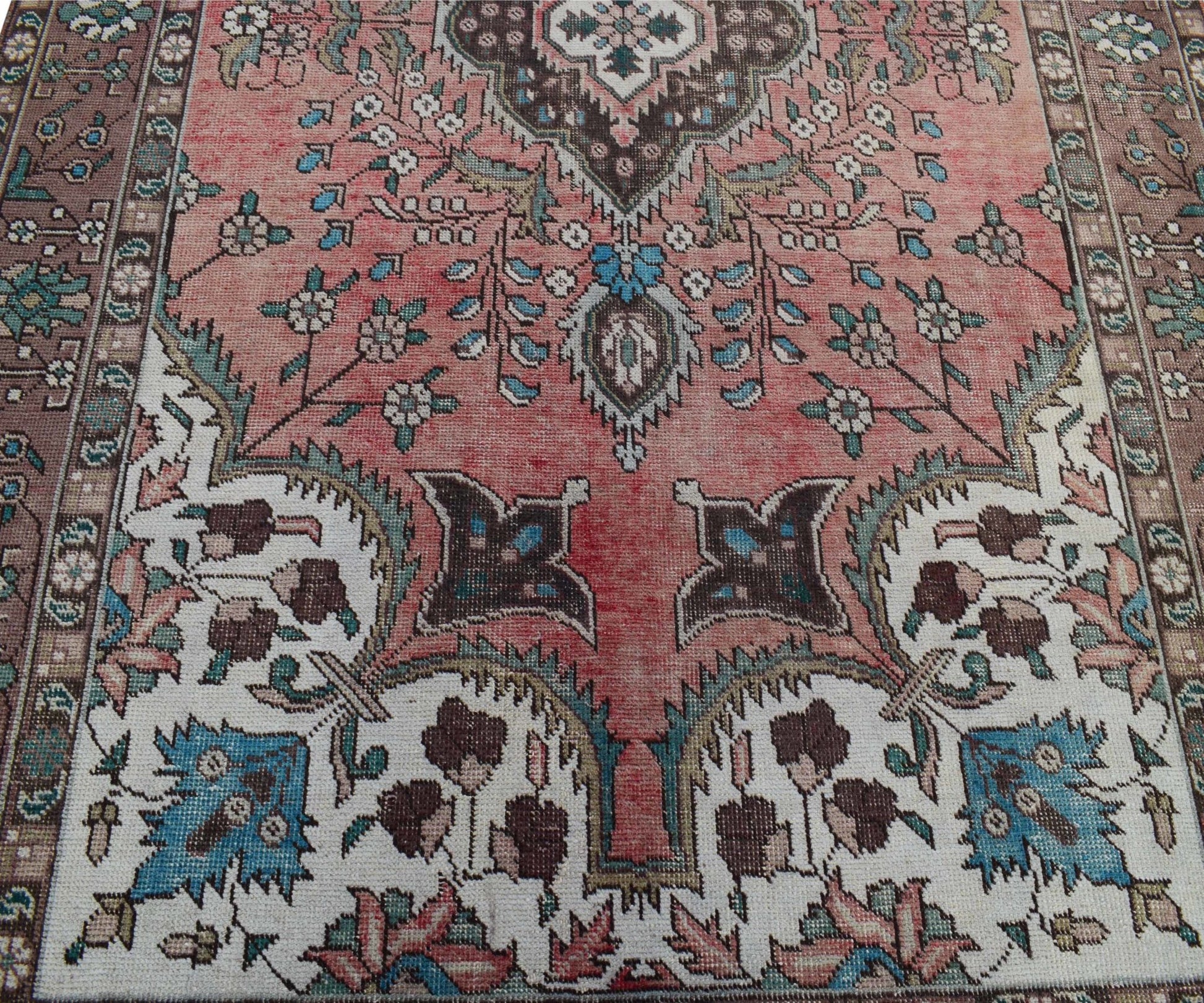 A vintage Persian Tabriz rug featuring a central medallion and intricate floral patterns.