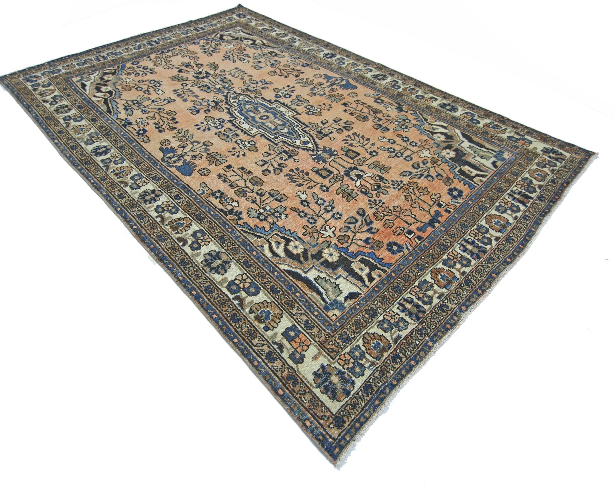 A vintage Persian Sarouk rug featuring a floral pattern in shades of peach, blue, and cream.