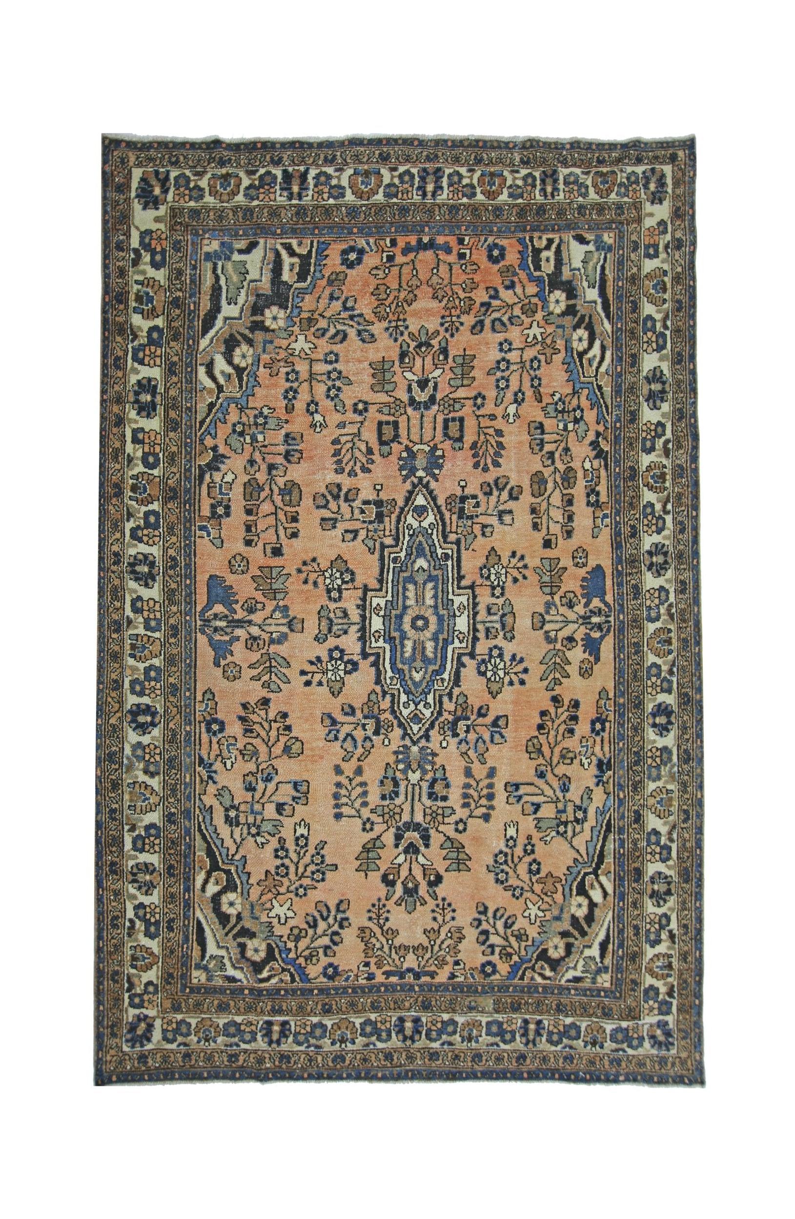 A vintage Persian Sarouk rug featuring a central floral medallion on a peach field with blue accents.