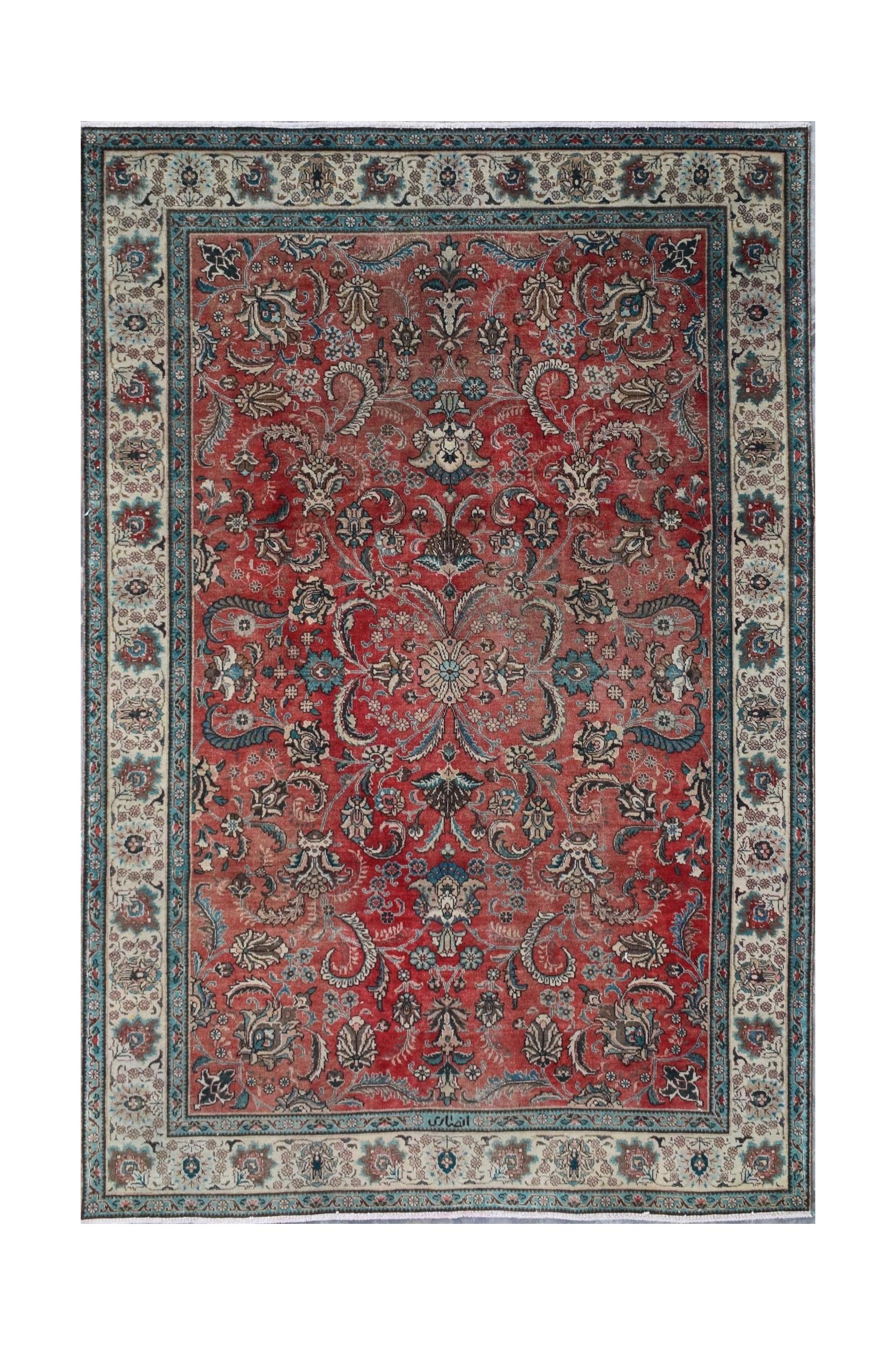 A vintage Persian Tabriz rug featuring an intricate floral medallion design on a red field.