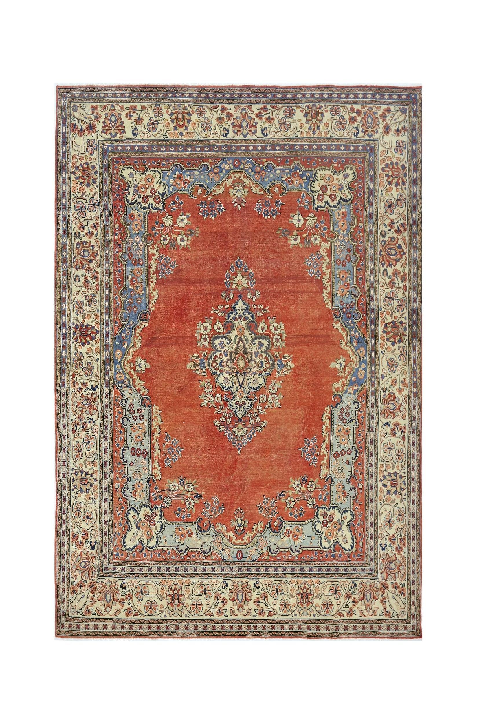 A vintage Persian Tabriz rug featuring a central floral medallion on a red field with blue borders.