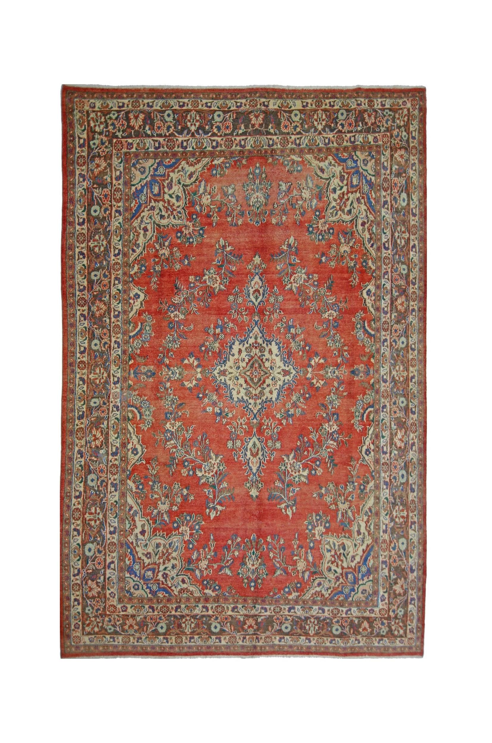 A vintage Persian Tabriz rug featuring a central floral medallion on a red field with ornate borders.