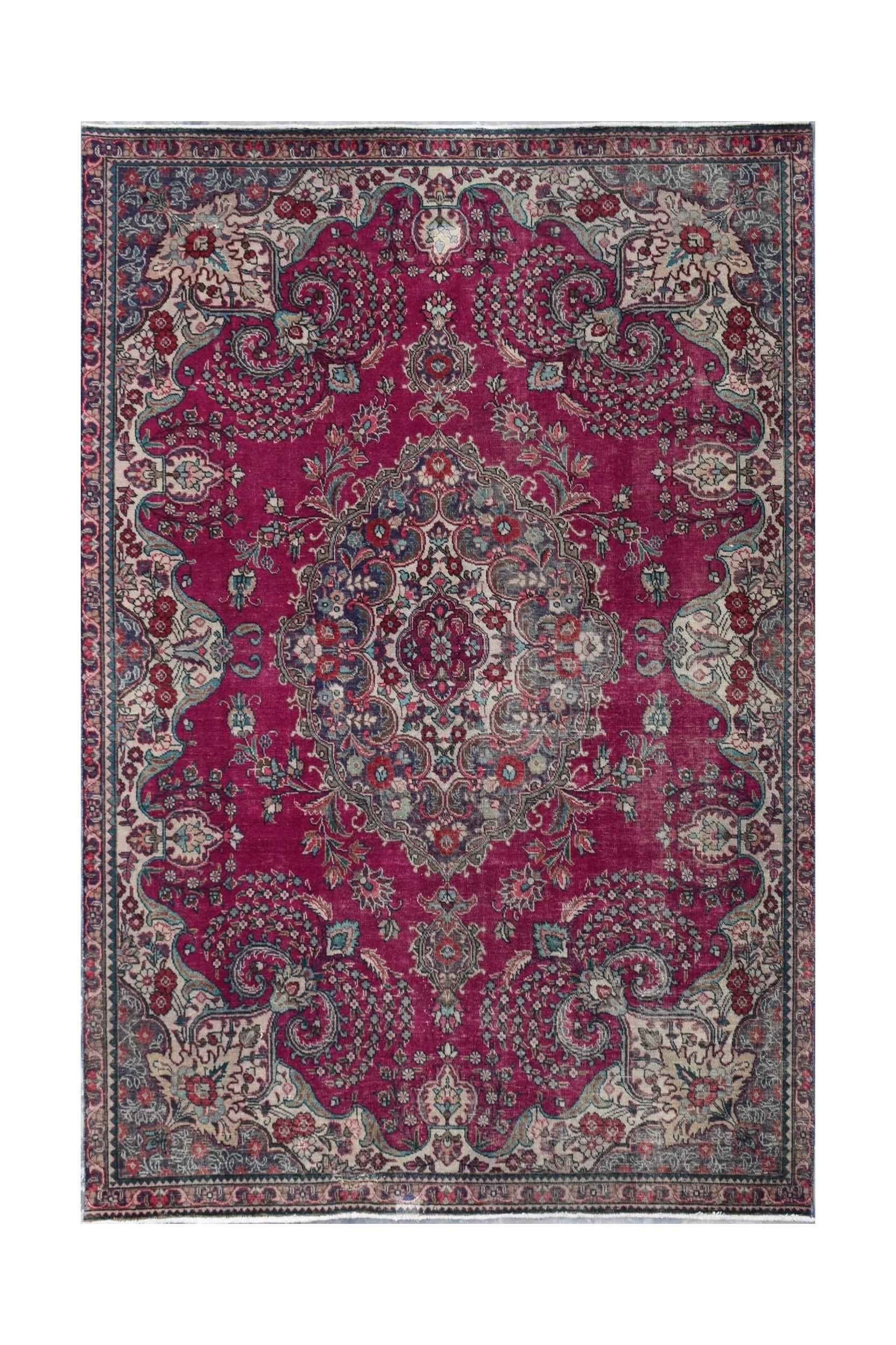 A vintage Persian Tabriz rug featuring a central floral medallion on a deep magenta field.