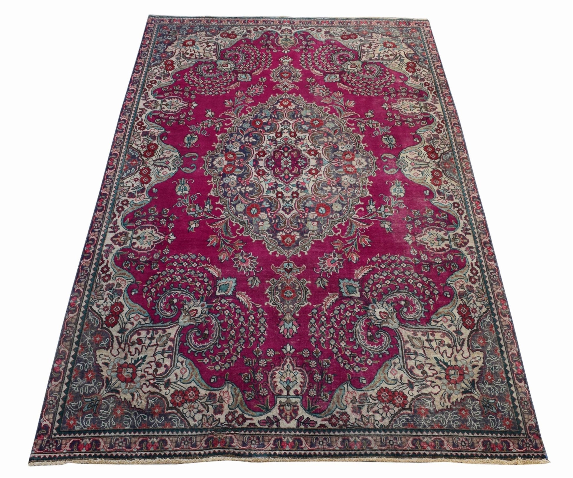 A vintage Persian Tabriz rug featuring an intricate floral medallion on a deep magenta field.