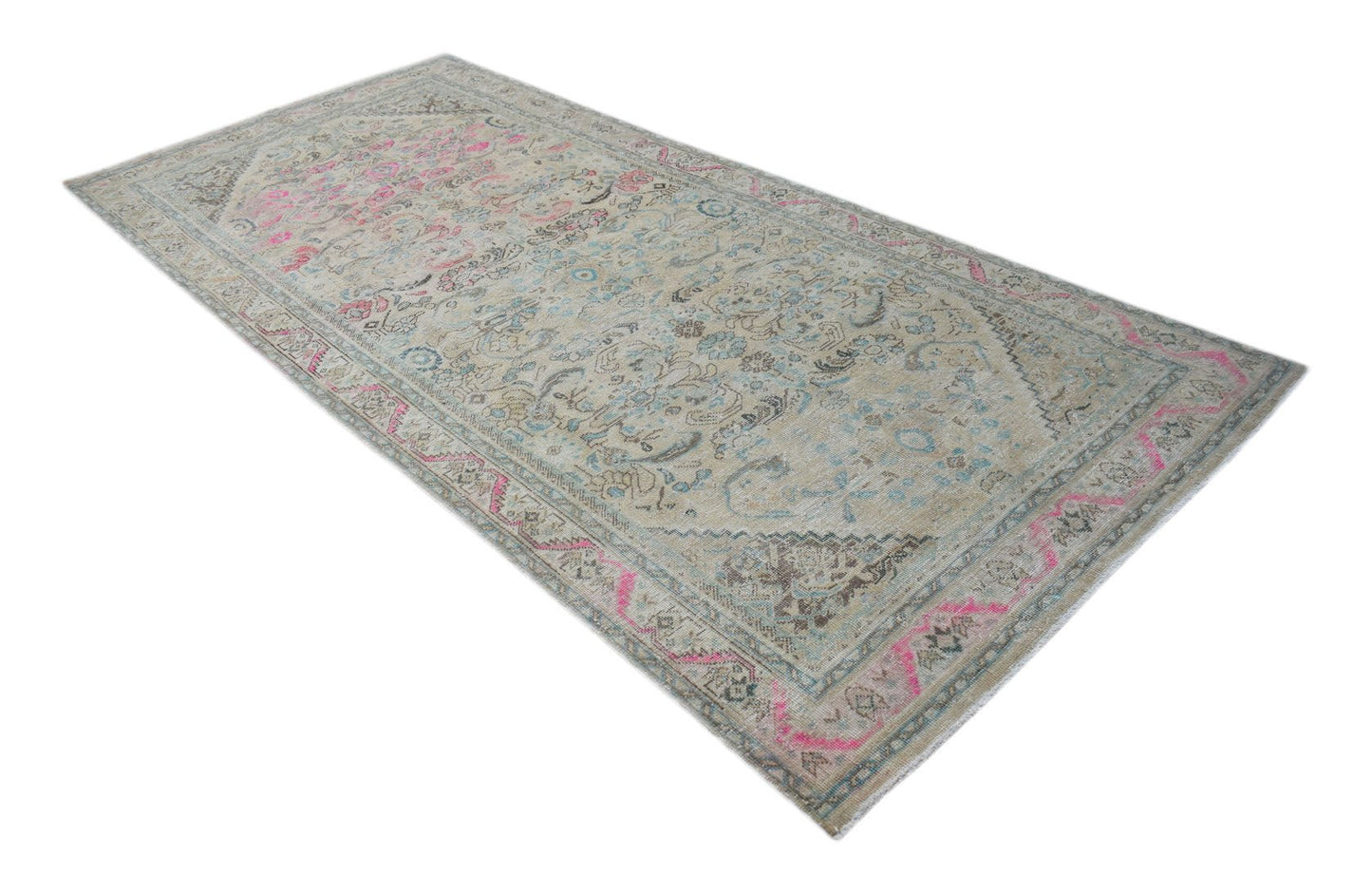 A vintage Persian Tabriz rug featuring a faded floral pattern in beige, blue, and pink tones.