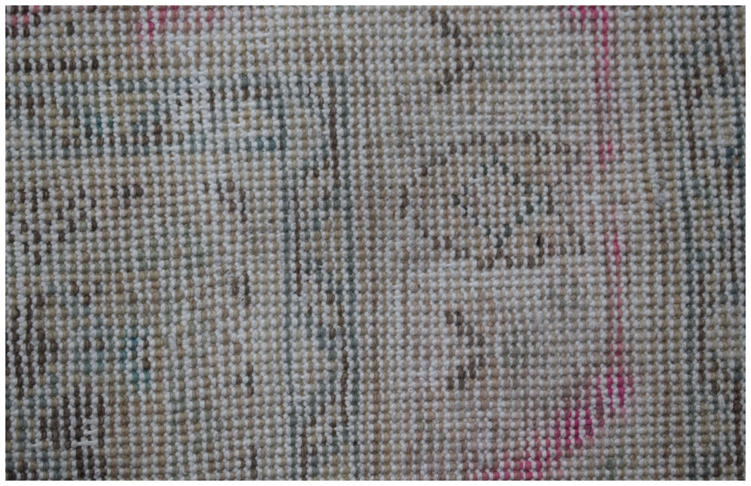 A close-up view of a vintage Persian Tabriz rug featuring a faded, intricate wool pattern.