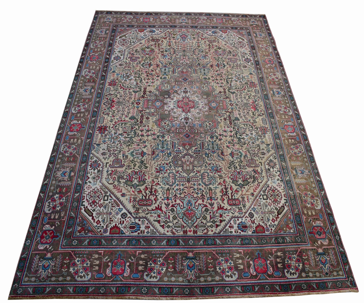 A vintage handwoven Persian Tabriz rug featuring intricate floral patterns in a neutral palette.