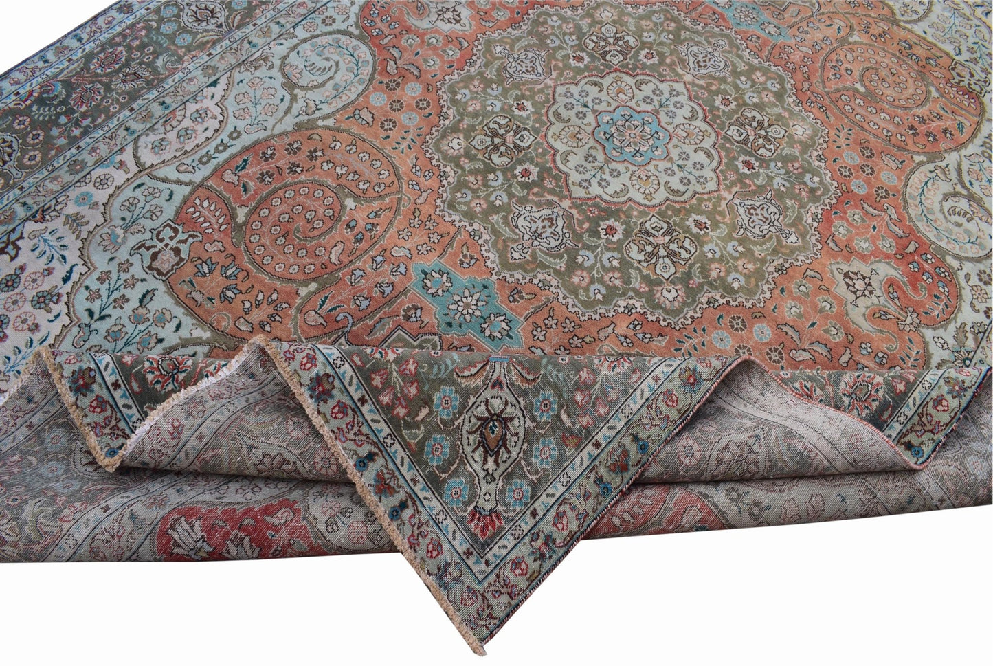 A vintage handwoven Persian Tabriz rug featuring intricate floral patterns in muted earth tones.