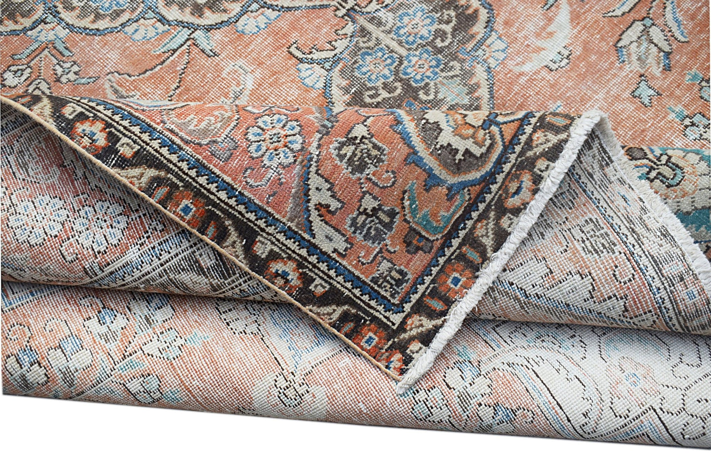 A vintage handwoven Persian Tabriz rug featuring intricate floral patterns in orange and blue tones.