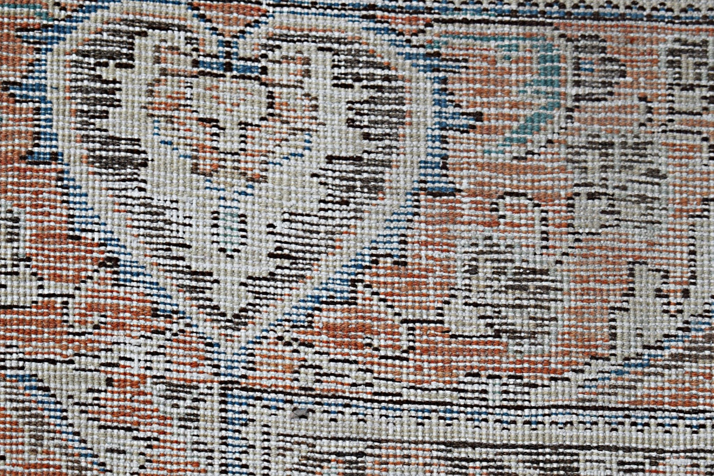 A close-up view of a vintage Persian Tabriz rug featuring intricate floral patterns in muted tones.