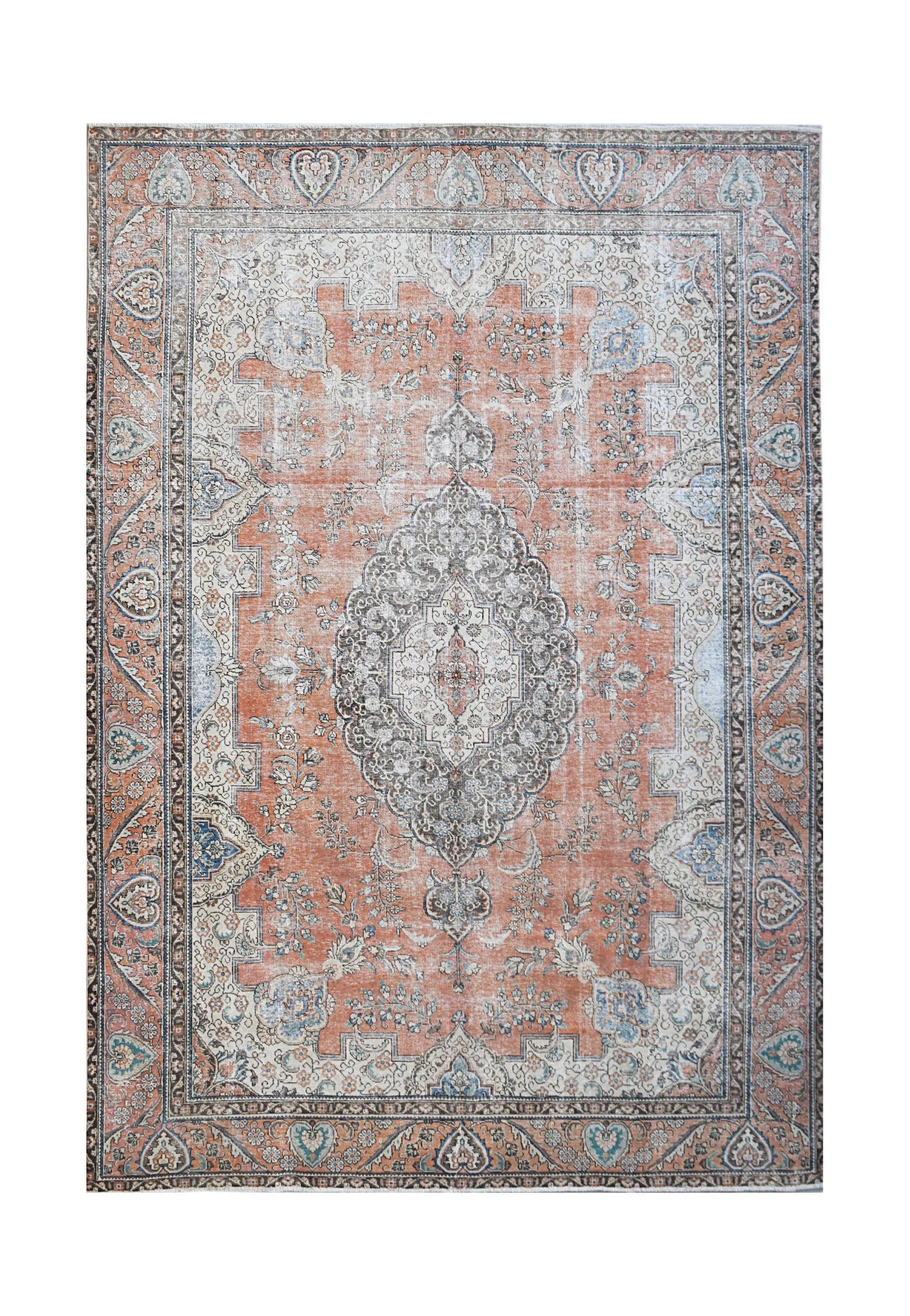 A vintage Persian Tabriz rug featuring a central medallion and floral patterns in orange and grey.