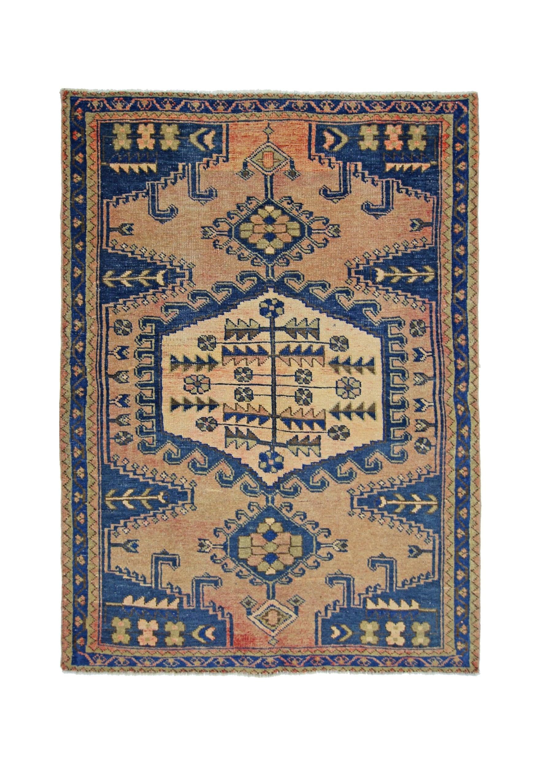 A vintage Persian Wiss rug featuring a geometric floral medallion on a peach and blue field.