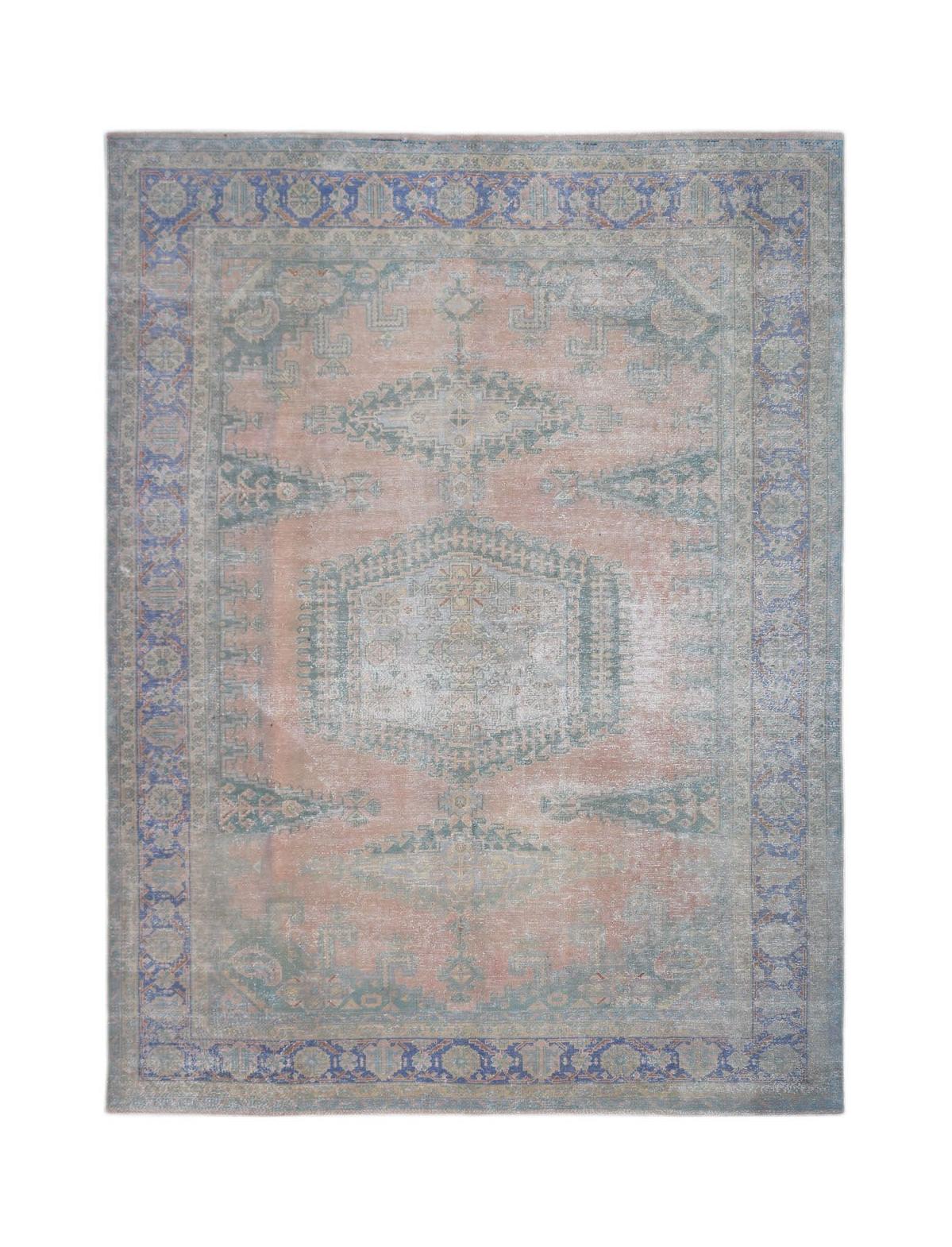 A vintage Persian rug featuring a central medallion and floral motifs in muted blue and peach tones.