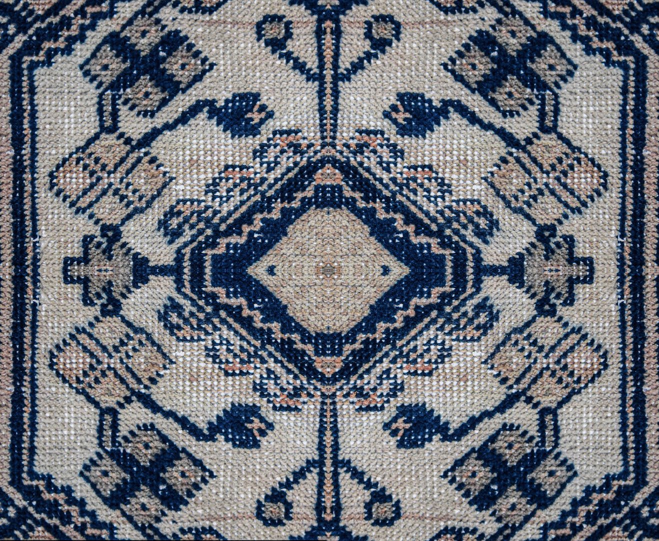A vintage Persian Wiss rug featuring a symmetrical blue and beige geometric pattern.