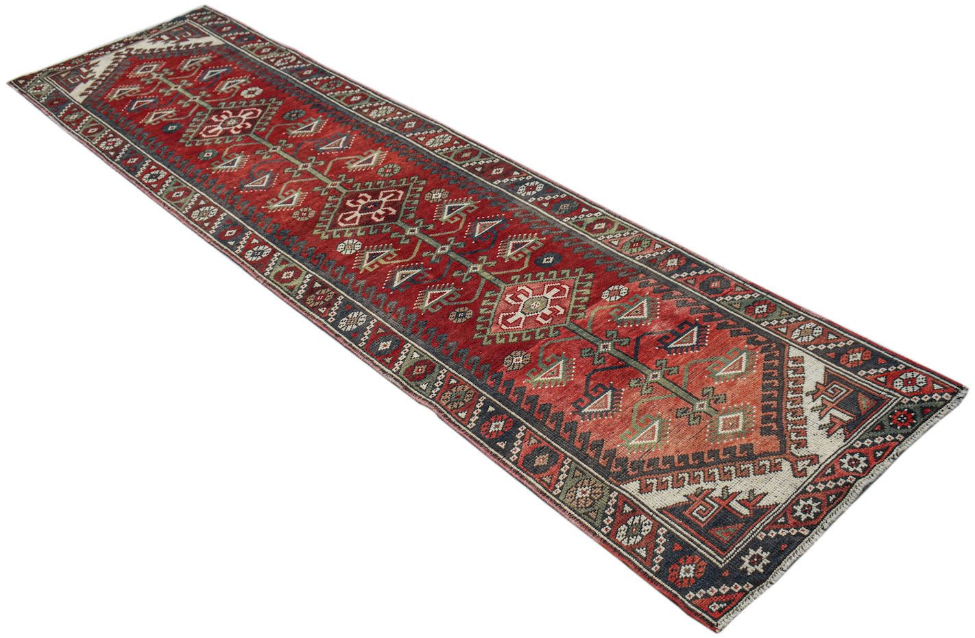 A handwoven vintage Persian runner rug featuring geometric patterns in red, blue, and cream tones.