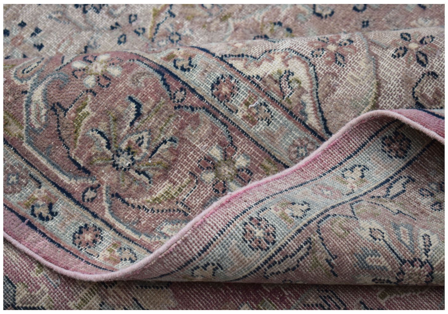 A vintage Persian Kerman rug featuring a soft pink palette with intricate floral medallion patterns.