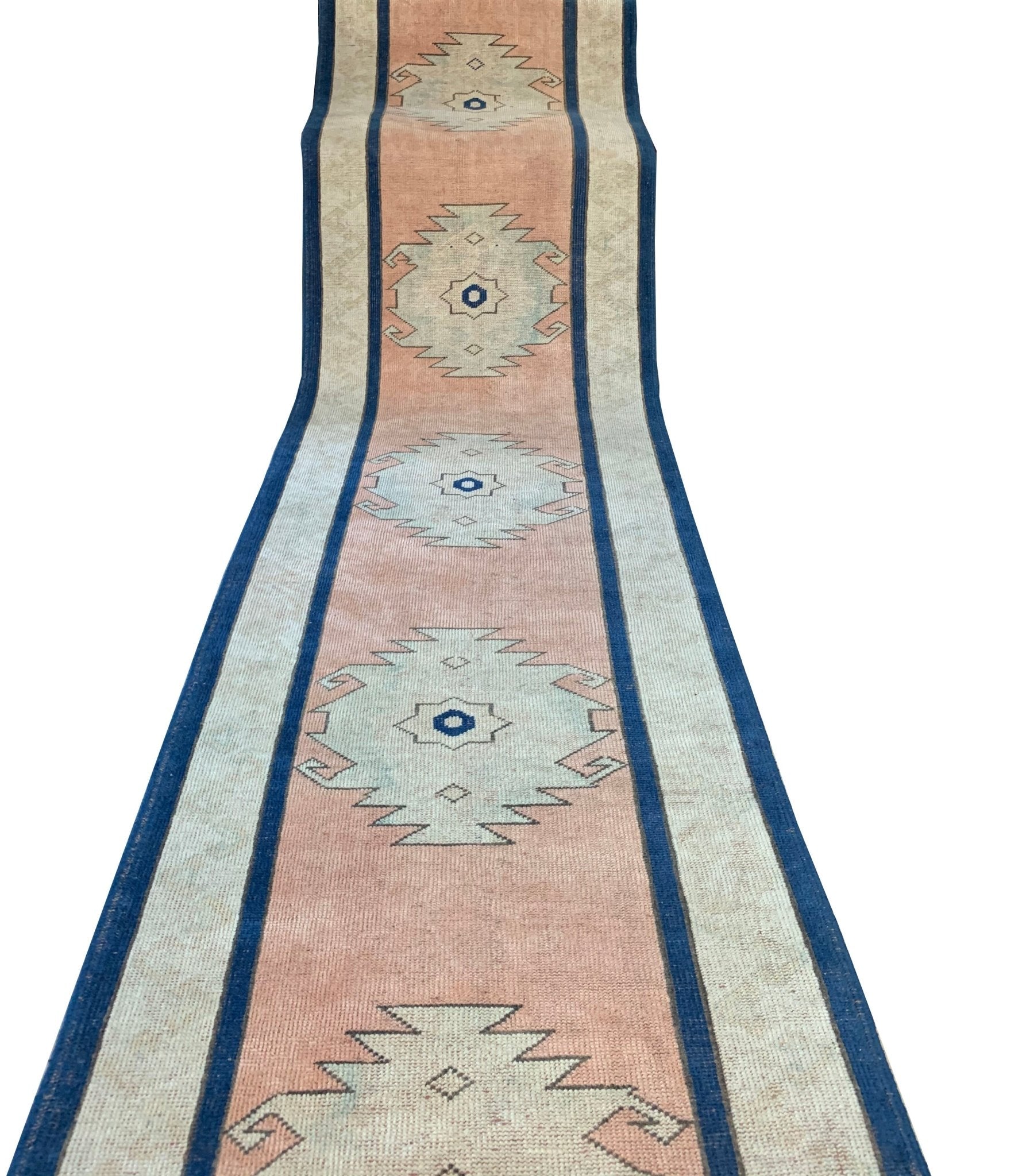 A vintage Turkish Oushak runner featuring tribal motifs in shades of pink, blue, and cream.