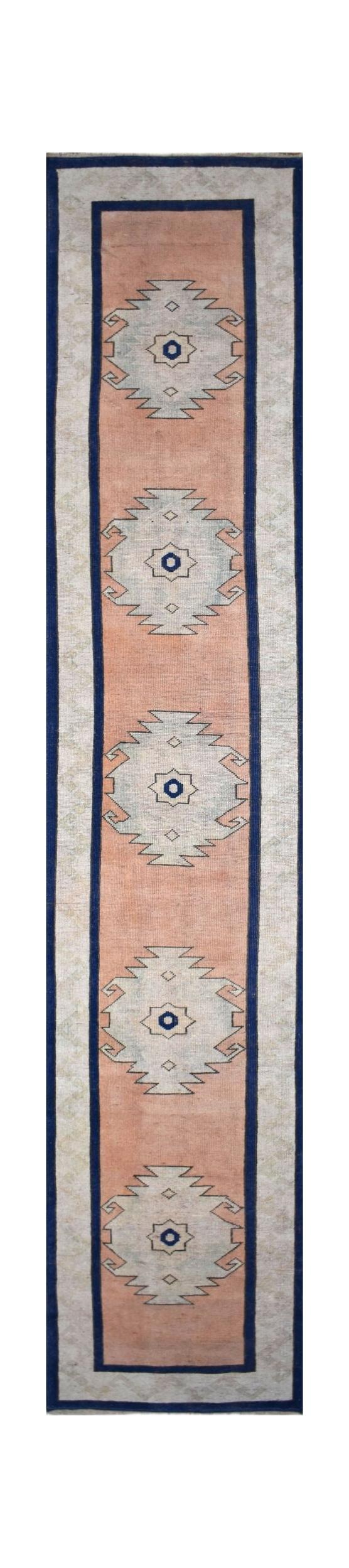 A vintage Turkish Oushak runner featuring five geometric medallions on a peach field.