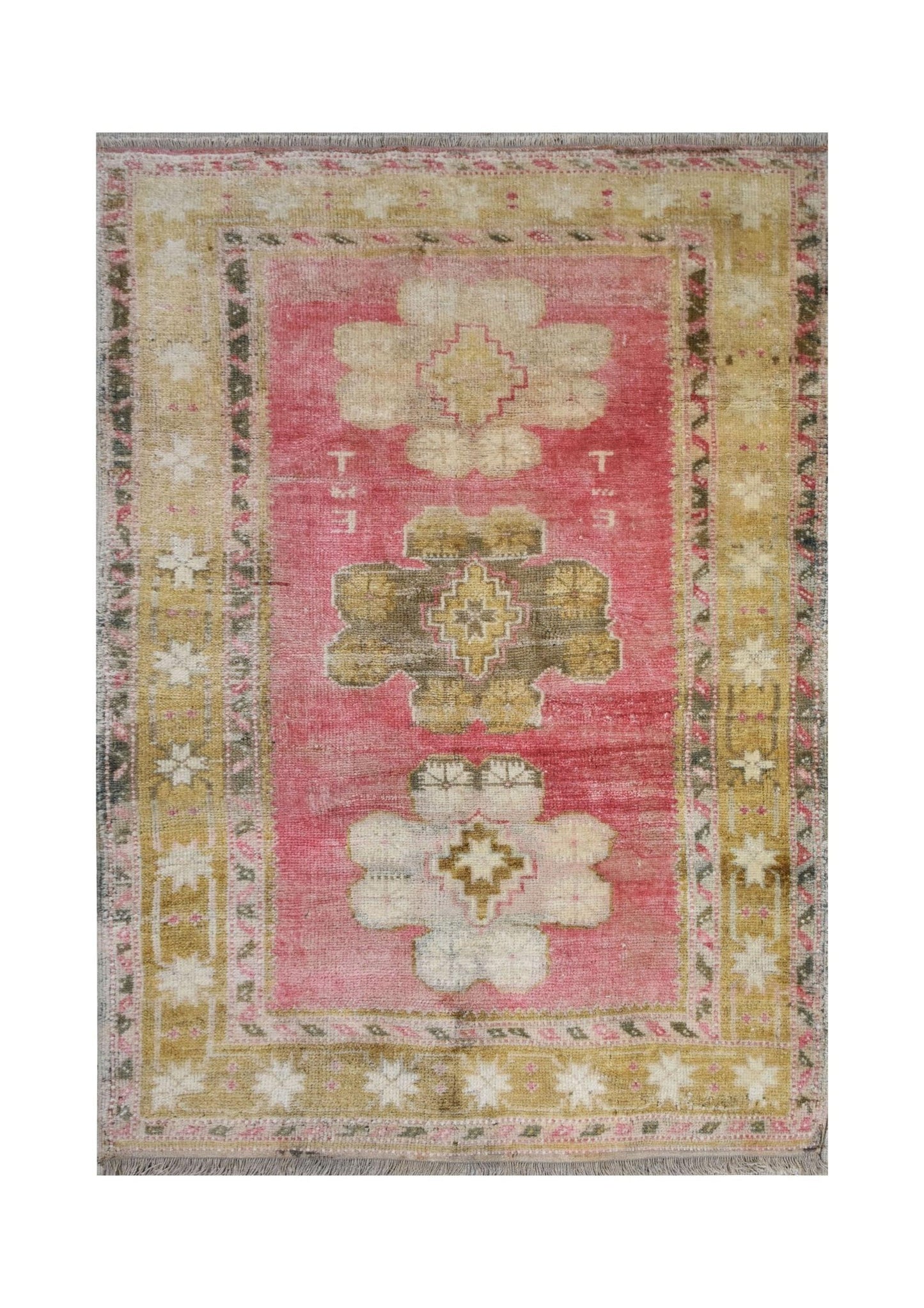 A vintage handmade Turkish Oushak rug featuring a pink field with tribal floral motifs.
