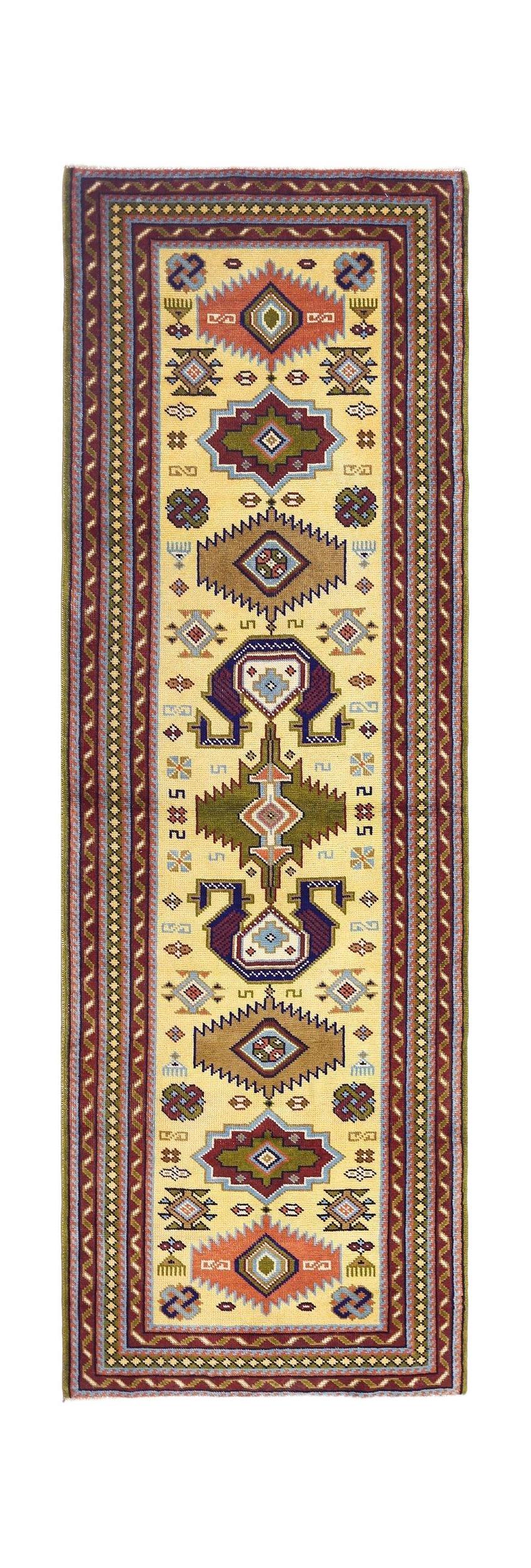 A handmade vintage Turkish runner rug featuring geometric tribal motifs on a cream background.