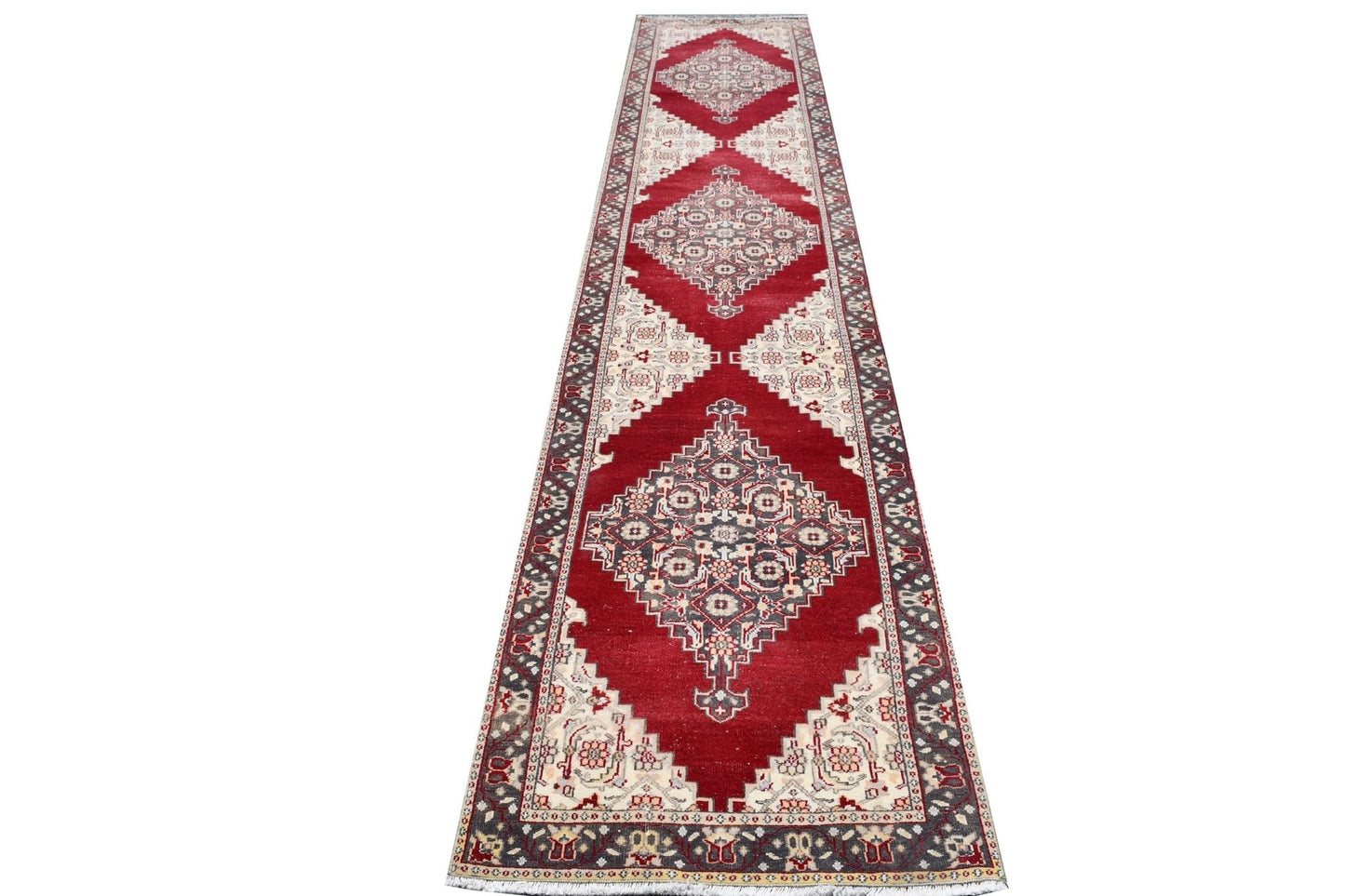 Vintage Turkish runner with red, cream, and gray geometric patterns.