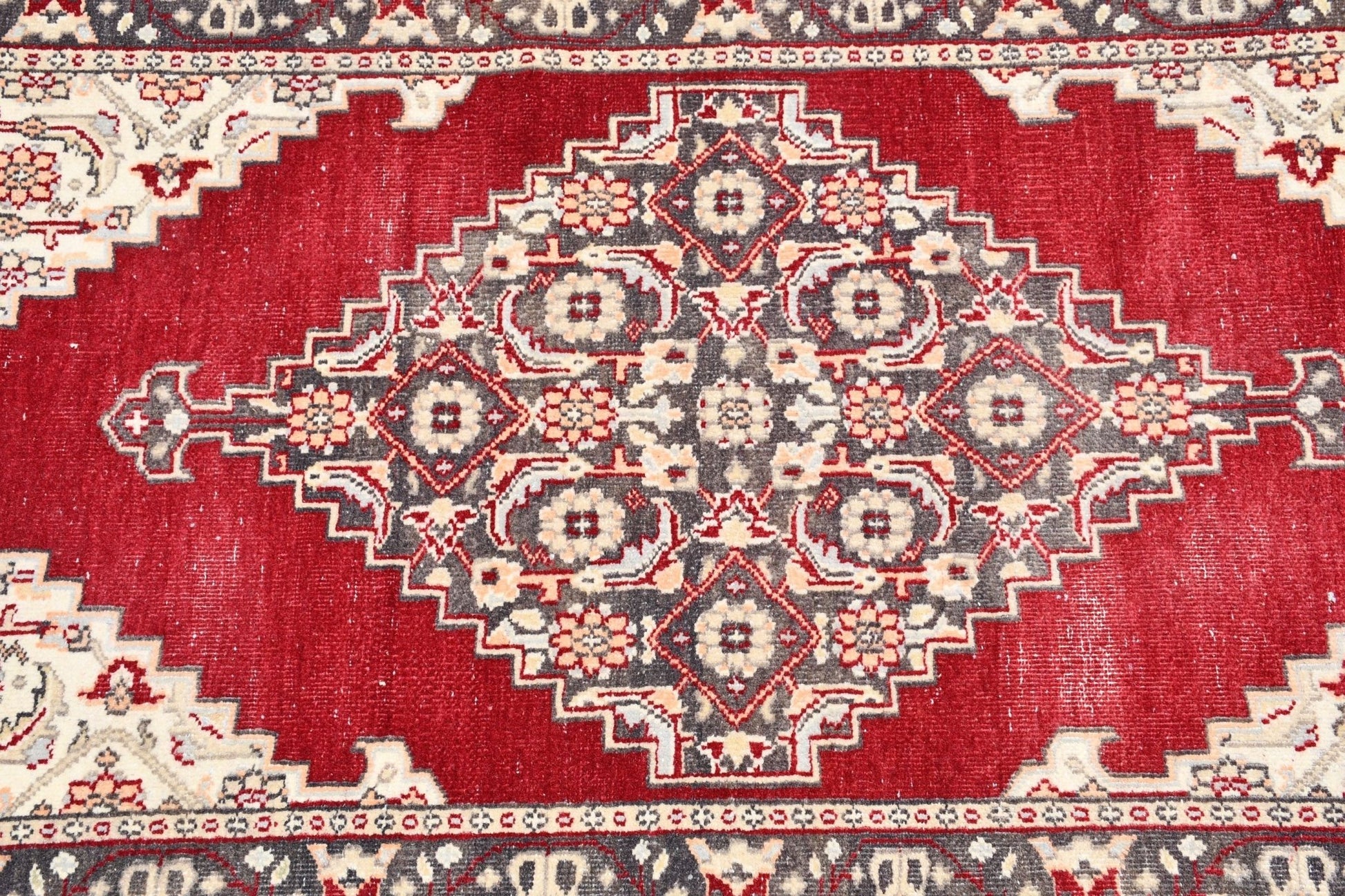 Vintage Turkish runner with a red field and a central diamond medallion.