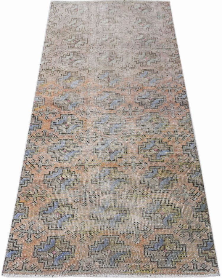 A vintage Turkish Isparta runner rug featuring a repeating geometric pattern in muted tones.