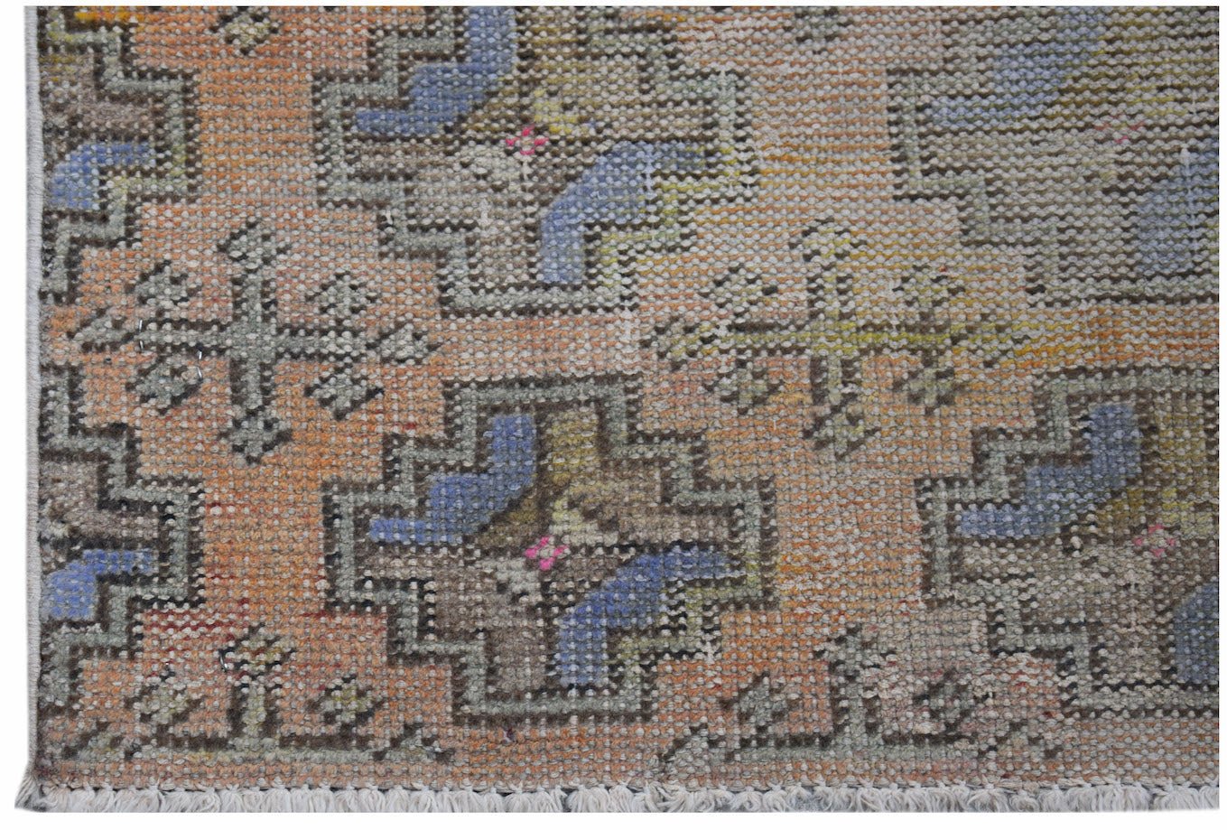 A vintage Turkish Isparta runner featuring a geometric pattern in orange, blue, and muted tones.