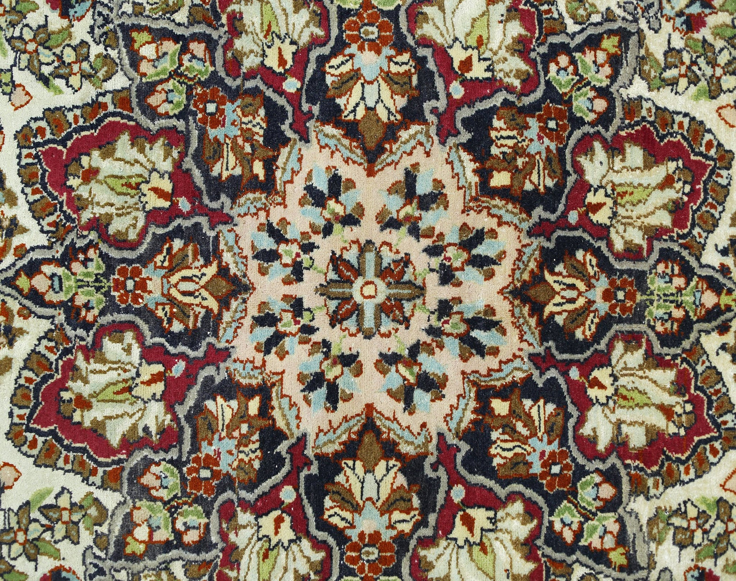 A vintage Turkish Kayseri rug featuring a detailed floral medallion pattern in red and blue tones.