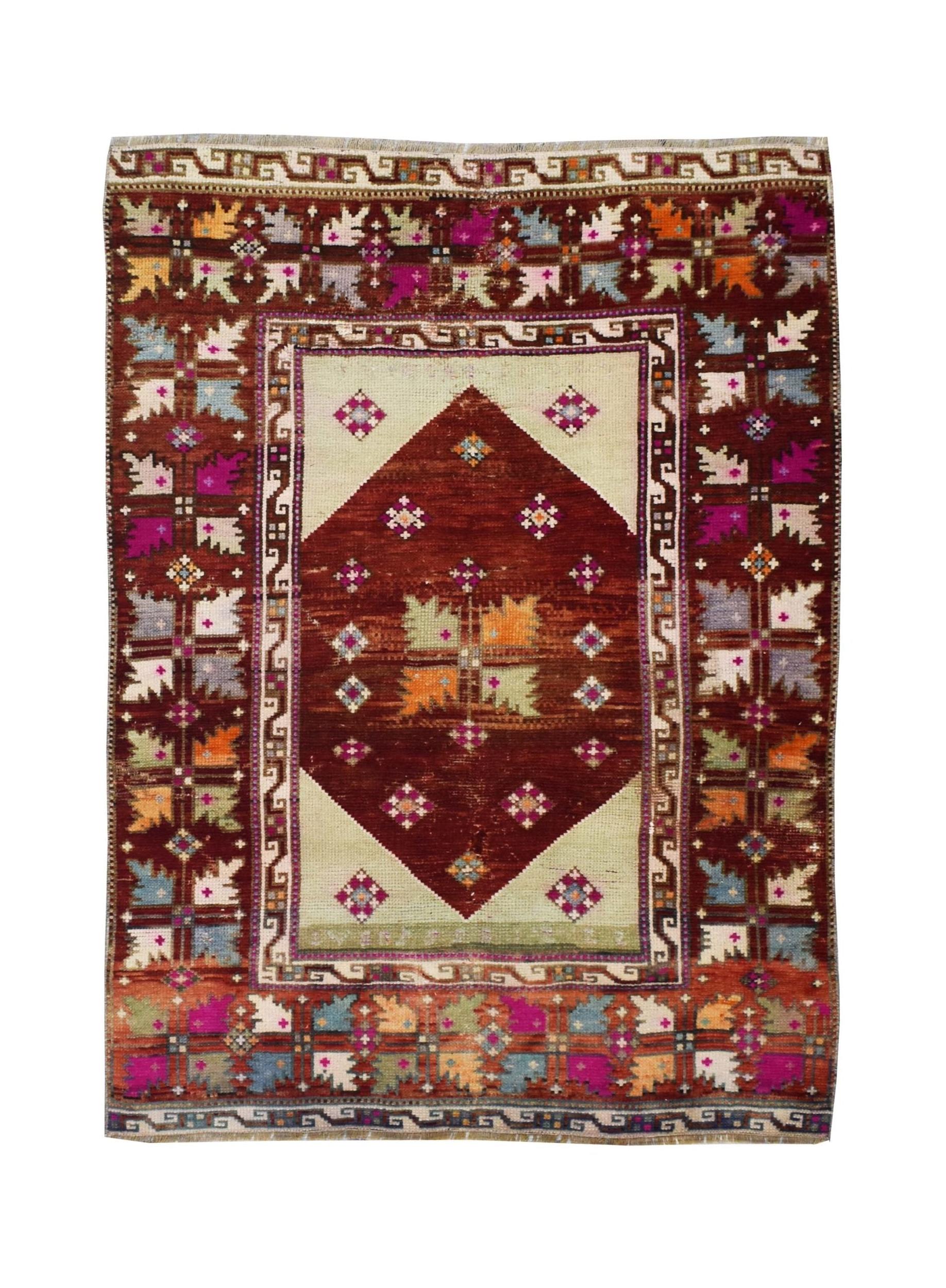 A vintage Turkish Kula rug featuring a central diamond motif and colorful geometric leaf patterns.