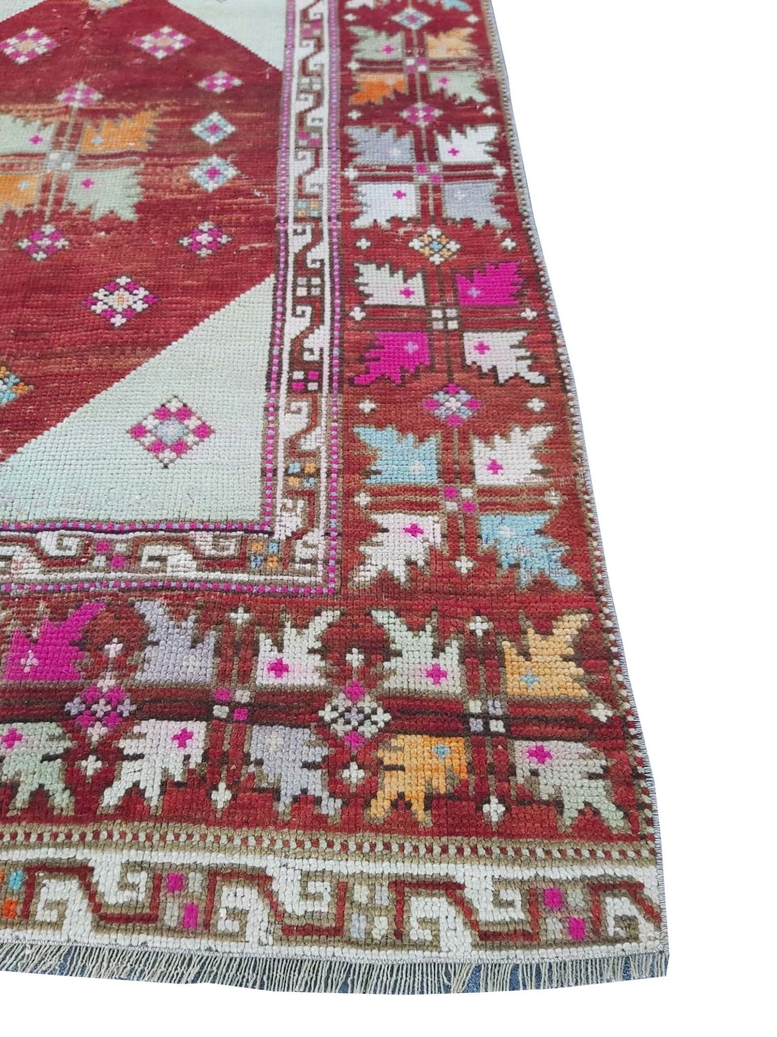 A vintage Turkish Kula rug featuring geometric patterns in a vibrant, multi-colored wool design.