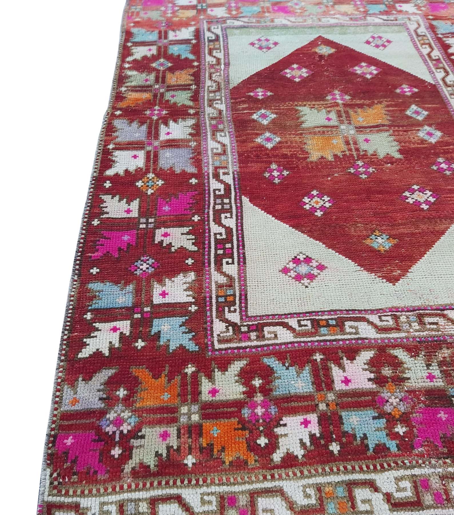 A vintage Turkish Kula rug featuring a red diamond medallion and geometric patterns in wool.