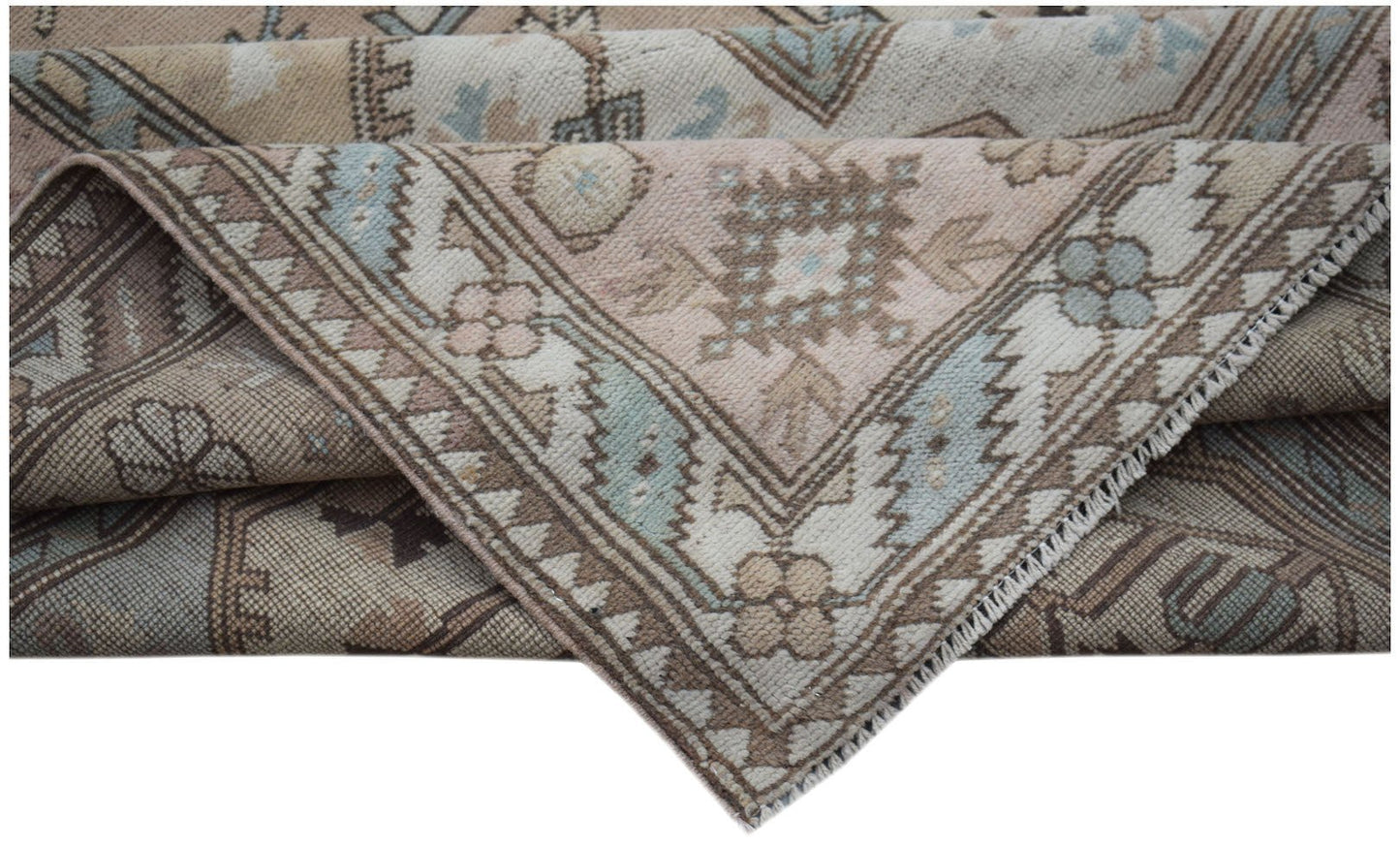 A vintage Turkish Milas rug featuring a traditional geometric pattern in soft pastel tones.