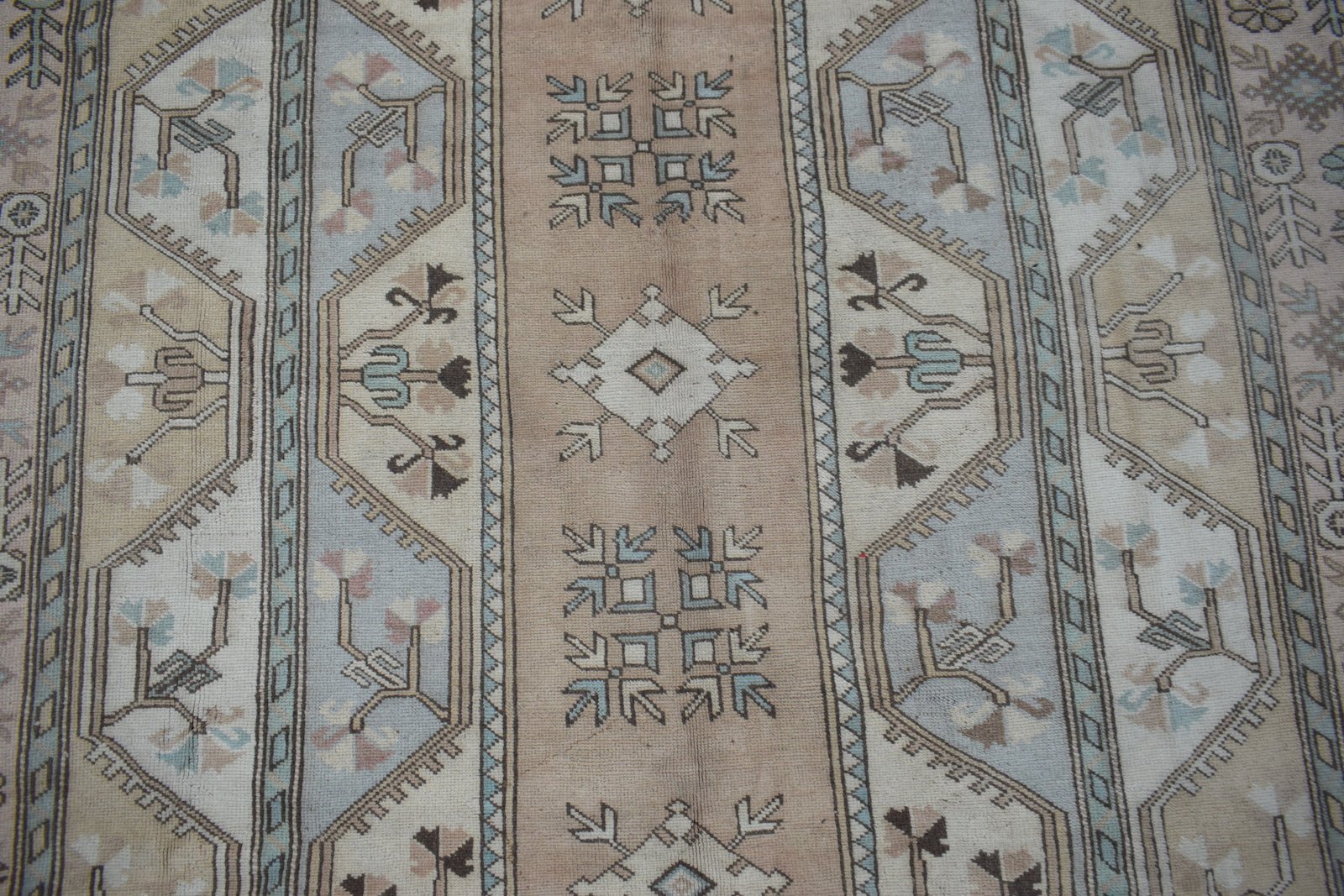 A vintage Turkish Milas rug featuring a traditional geometric pattern in soft blue and tan tones.
